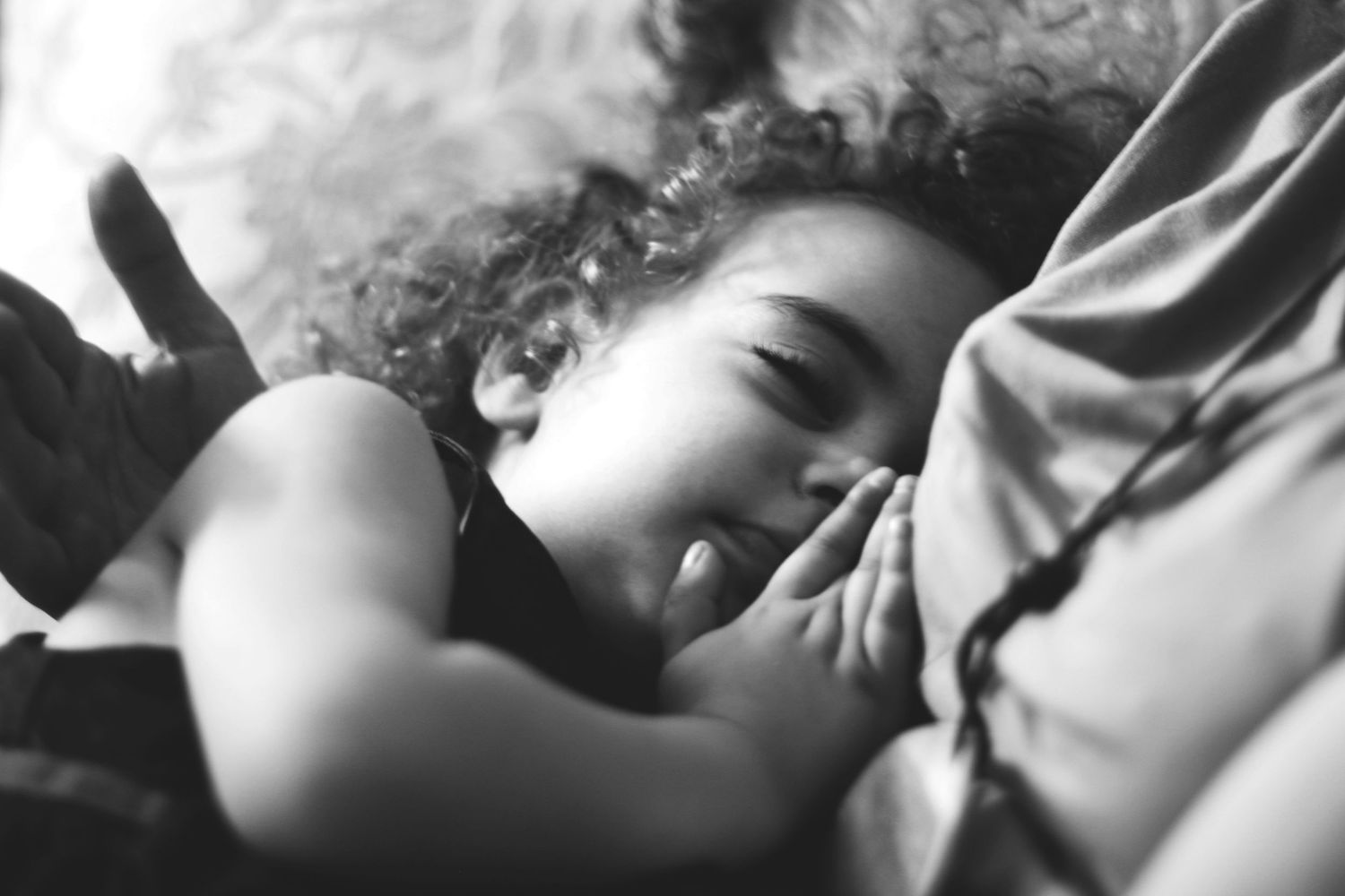 Black and white photo of a child resting peacefully in their mother's lab