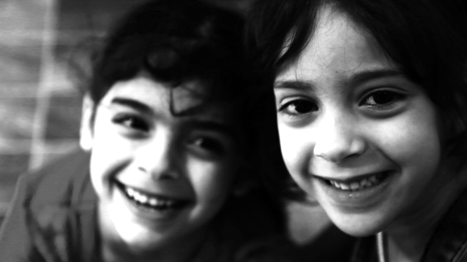 Black and white photo of two children smiling during a family photography session  in Ottawa