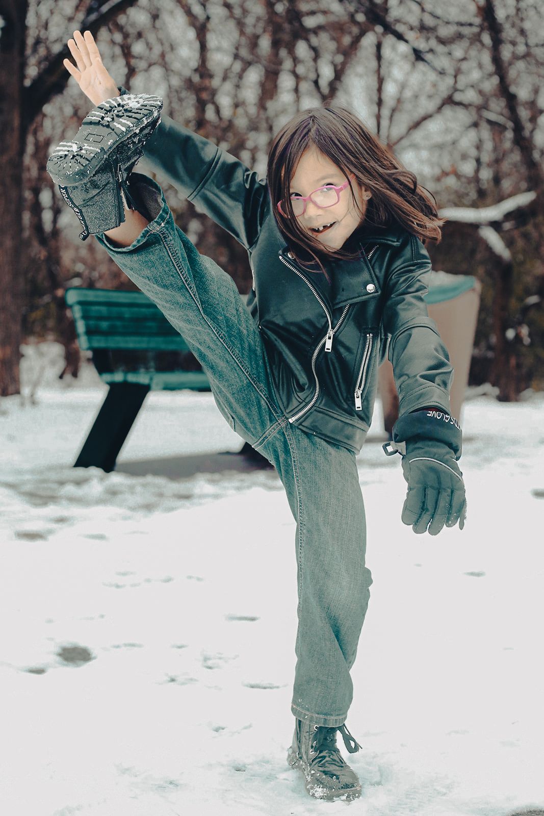 Child playing in the snow and showing off their karate skills during an outdoor family photography session in Ottawa