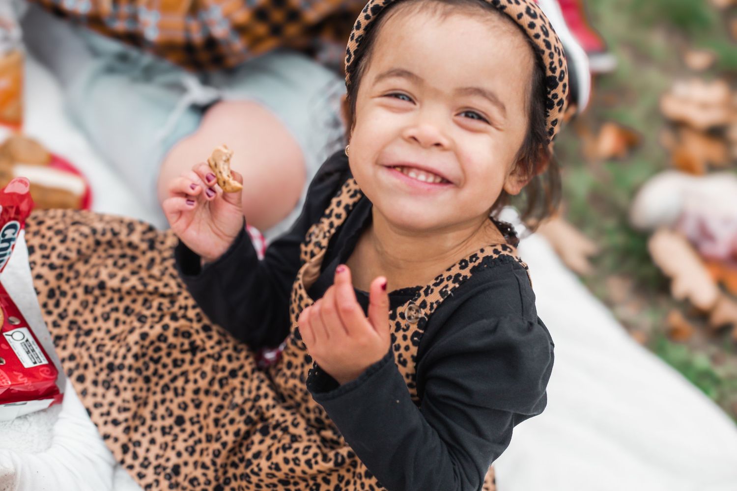 Ann energetic child laughing while eating and looking at the camera during a family photography session in Ottawa