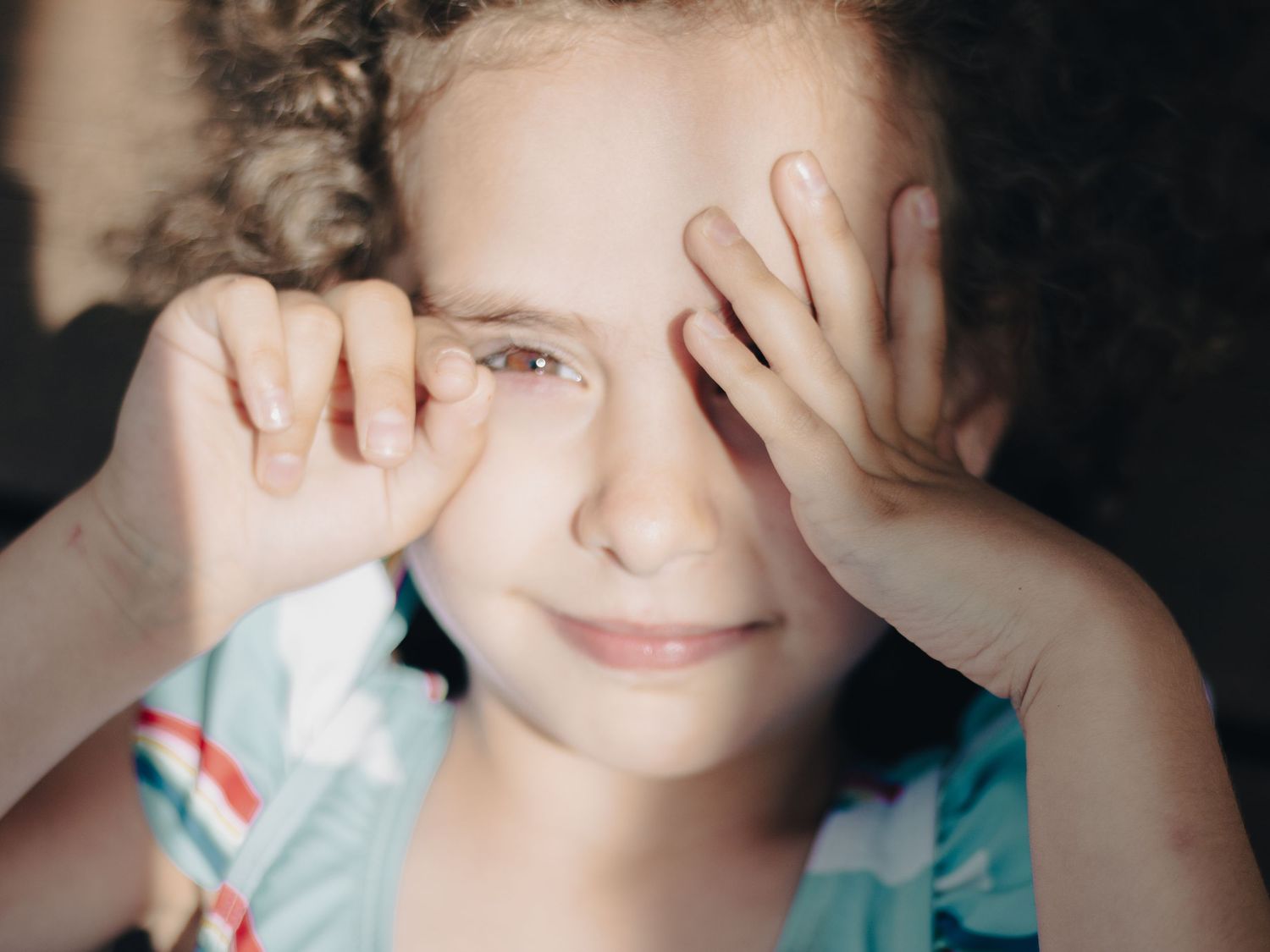 Child playing with her hands during a natural family photography session in Ottawa