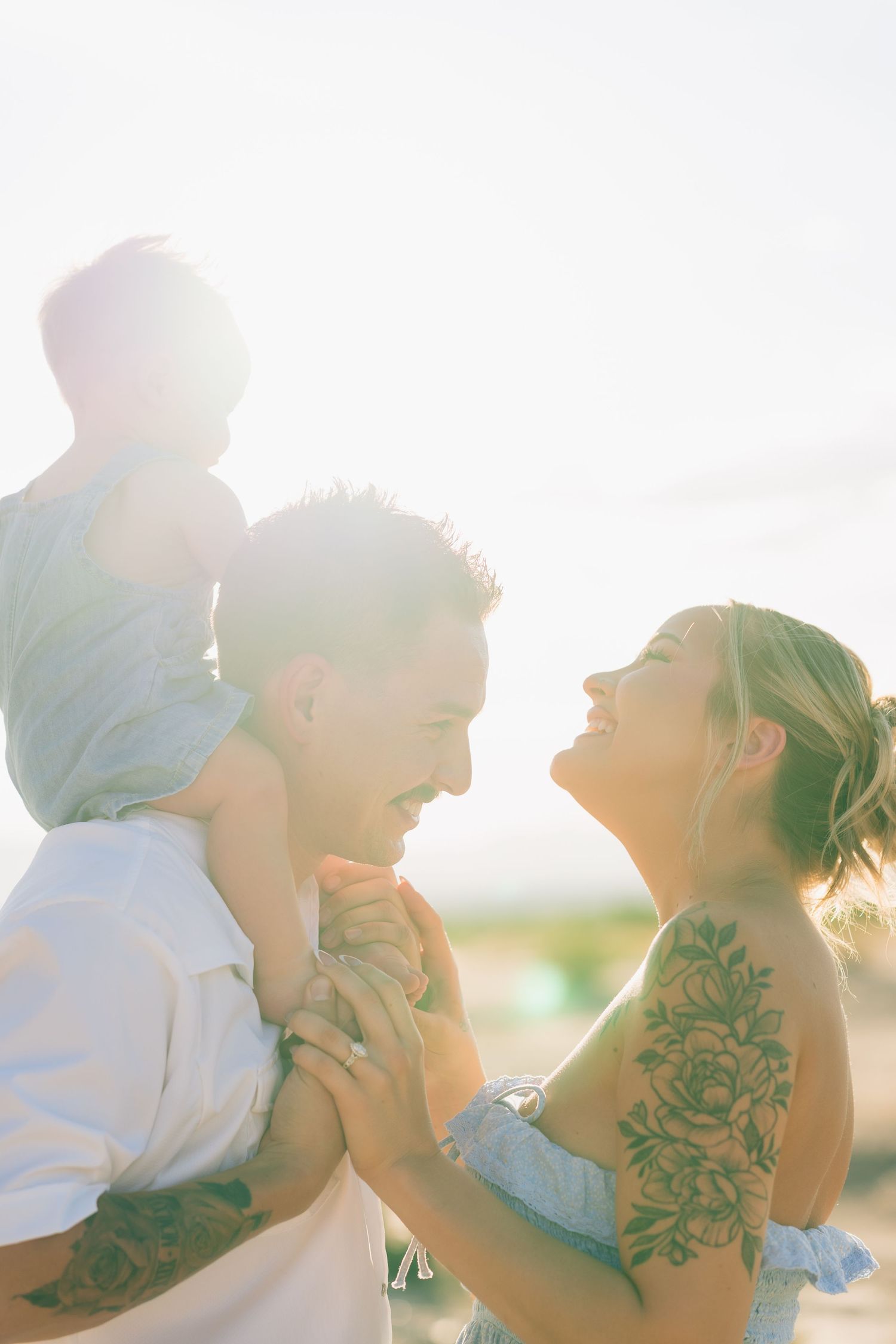 Parents and their toddler smiling and laughing during a desert family portrait shoot near Safford, Arizona.