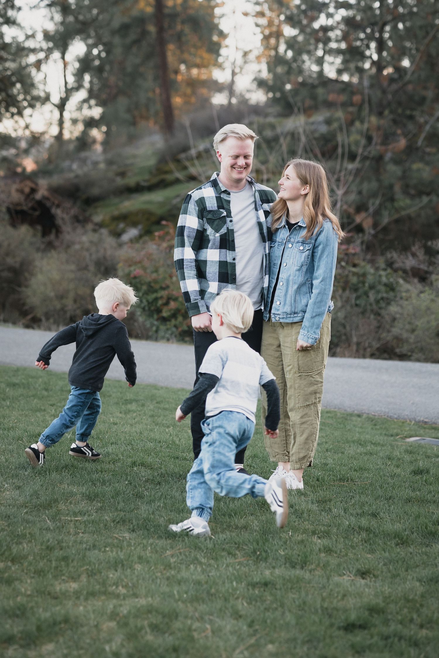 Family playing at sunset — Family with two young boys playing together on a grassy park path at sunset.