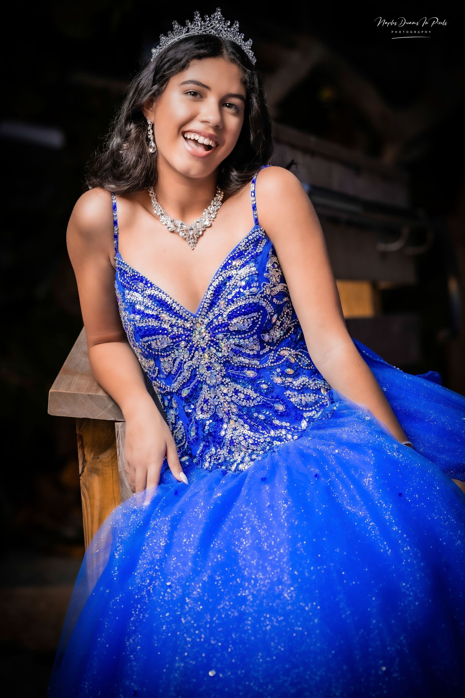 Smiling young woman in a royal blue strapless ballgown with a beaded corset bodice