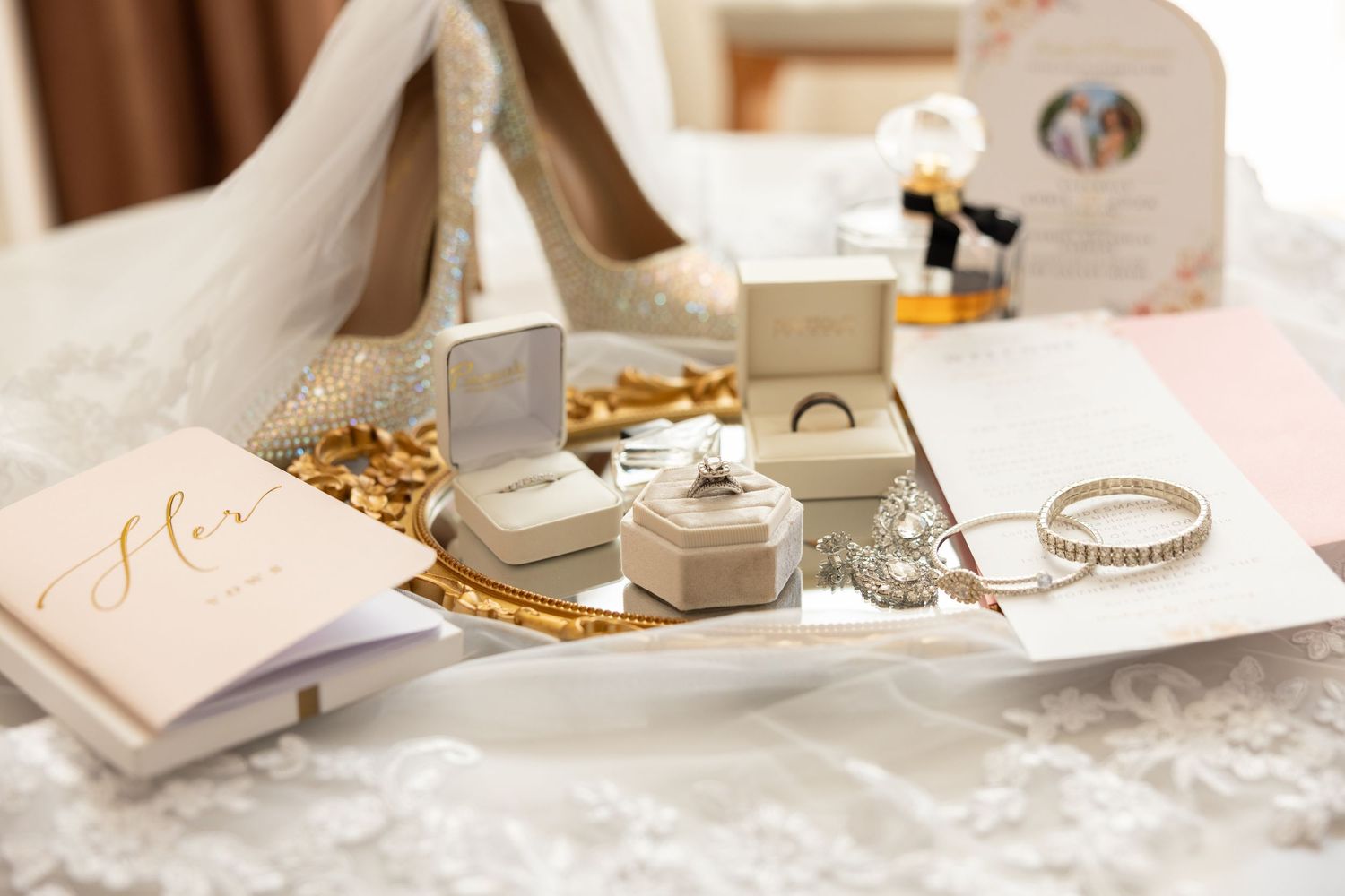 Background image showing a wedding flat lay with the wedding ring, bracelets, shoes, part of the wedding dress and more.