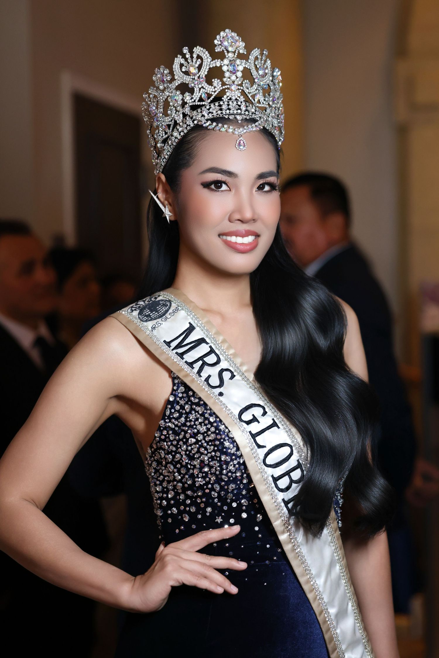 A smiling pageant contestant from wearing a large crystal tiara and a 