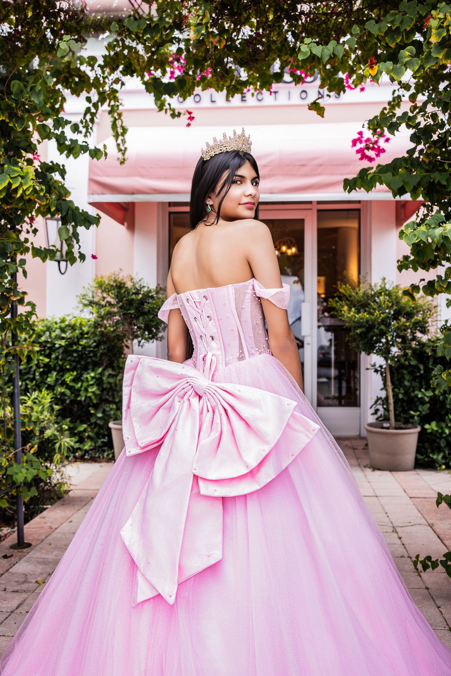 Back view of a pink strapless ballgown showing a large decorative bow detailing