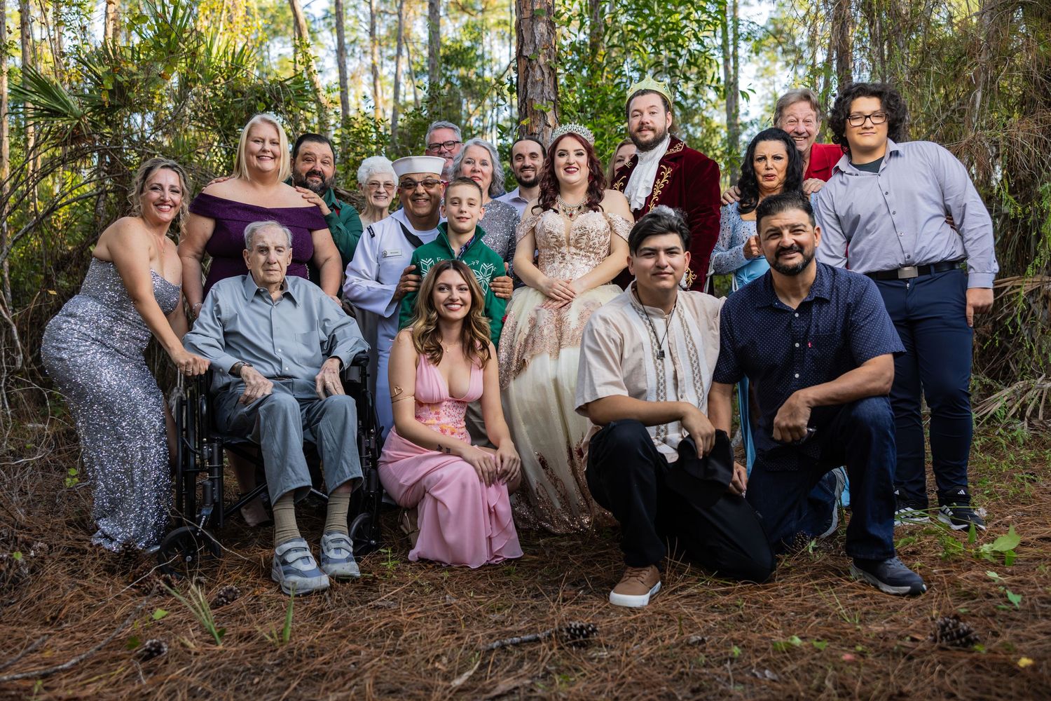 Multigenerational family posing for a group portrait outdoors at a rustic garden wedding celebration
