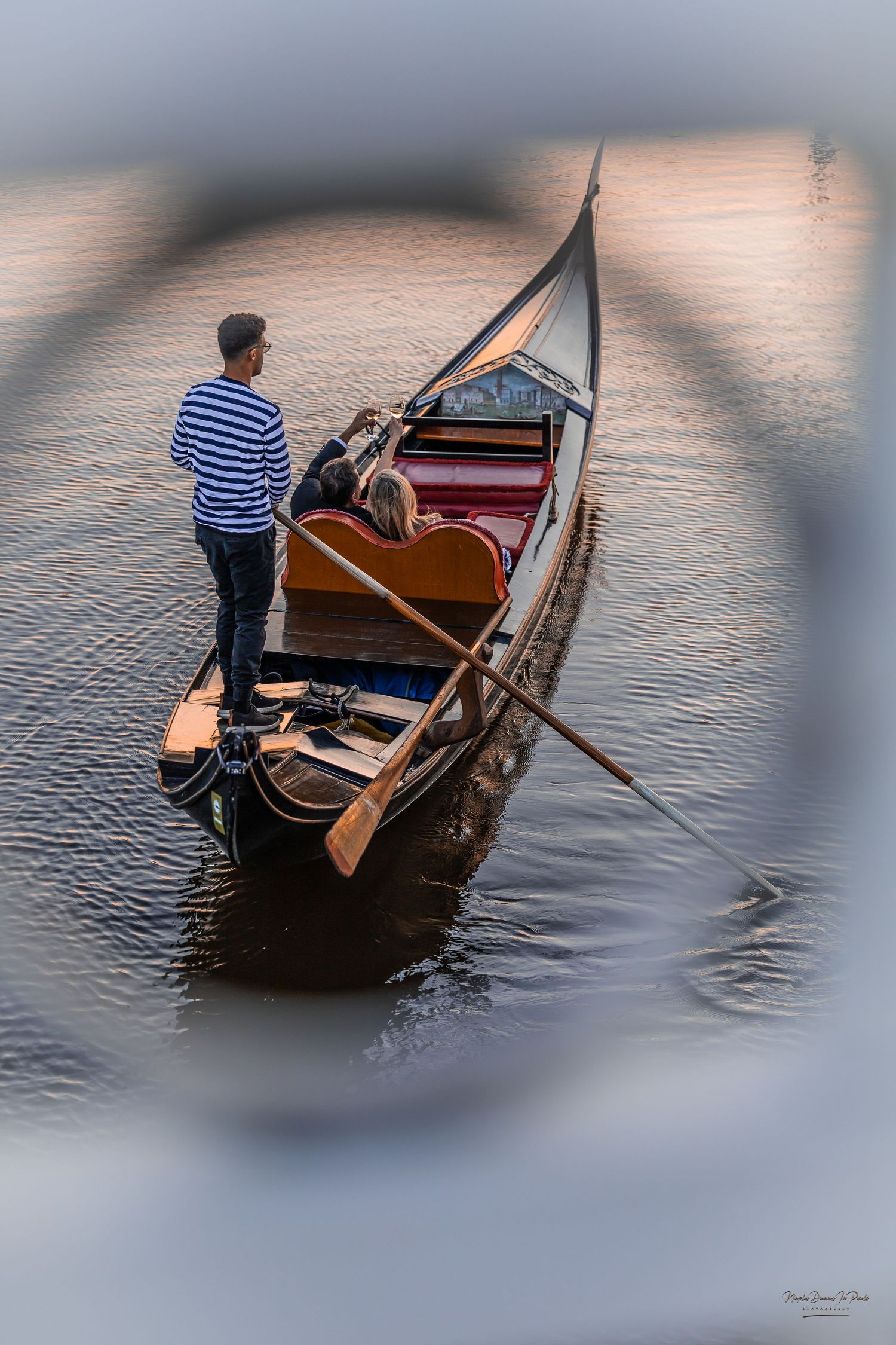 Gondolier rowboat viewed through a soft-focus architectural frame on calm water