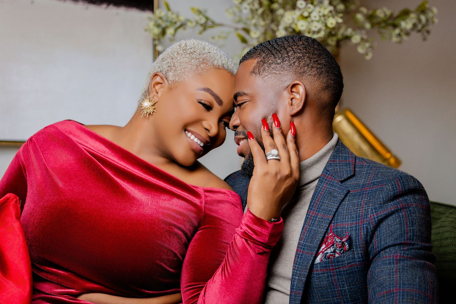 Affectionate couple smiling face-to-face, woman with short blonde hair showing her diamond engagement ring