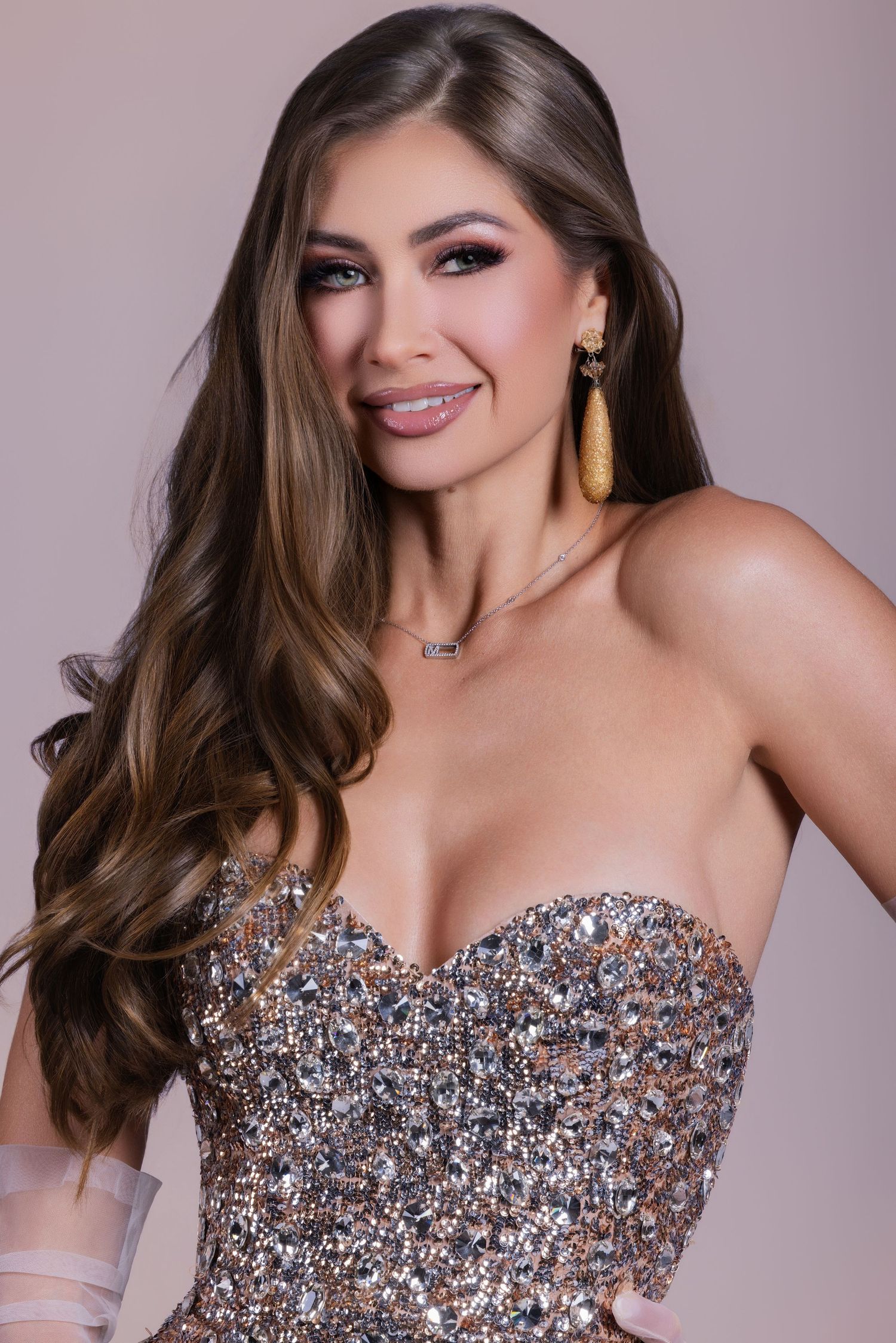 Glamour portrait of a woman with long wavy hair wearing a strapless metallic sequined sweetheart dress