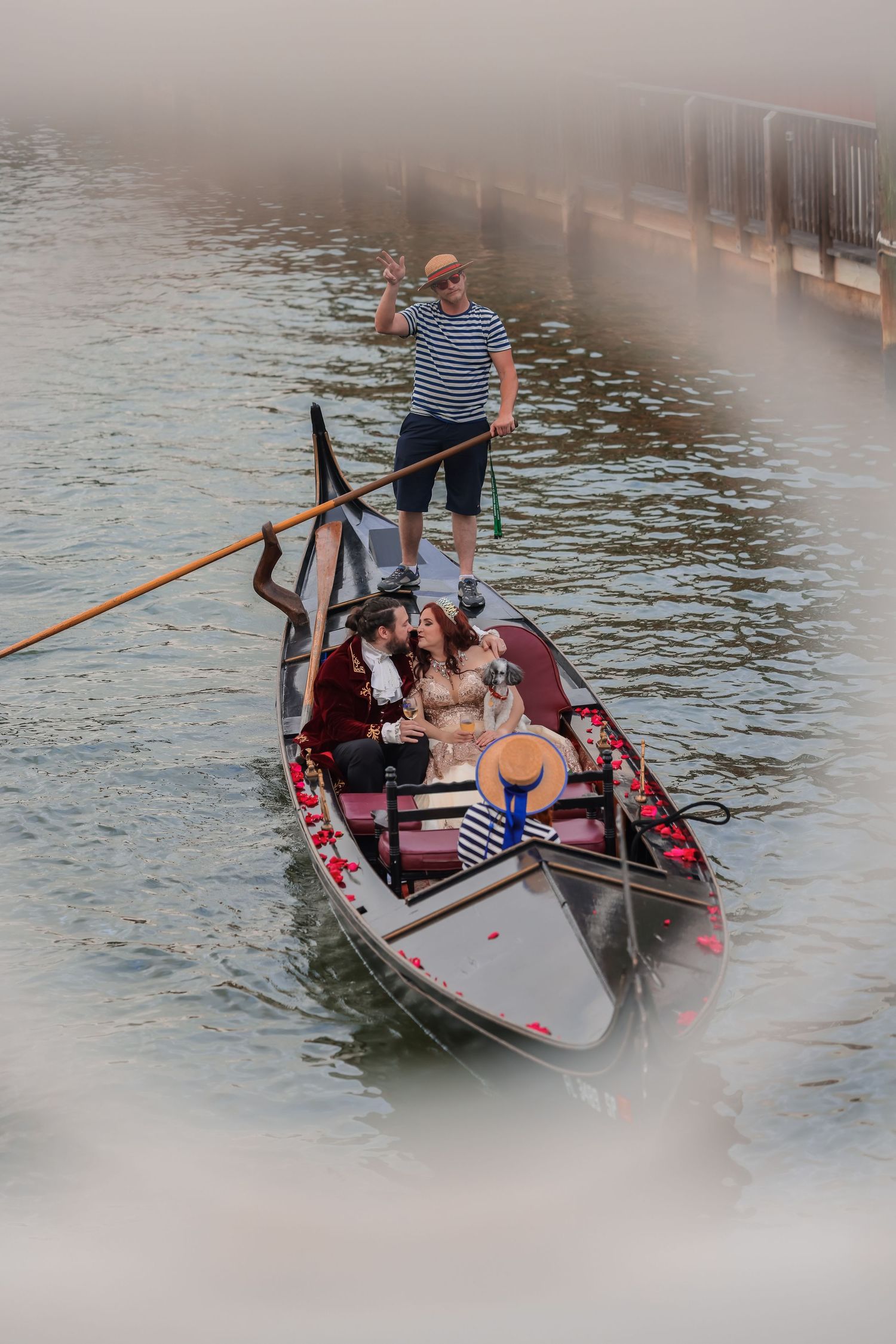 Gondolier rowing passengers down a river viewed through a soft focus architectural frame