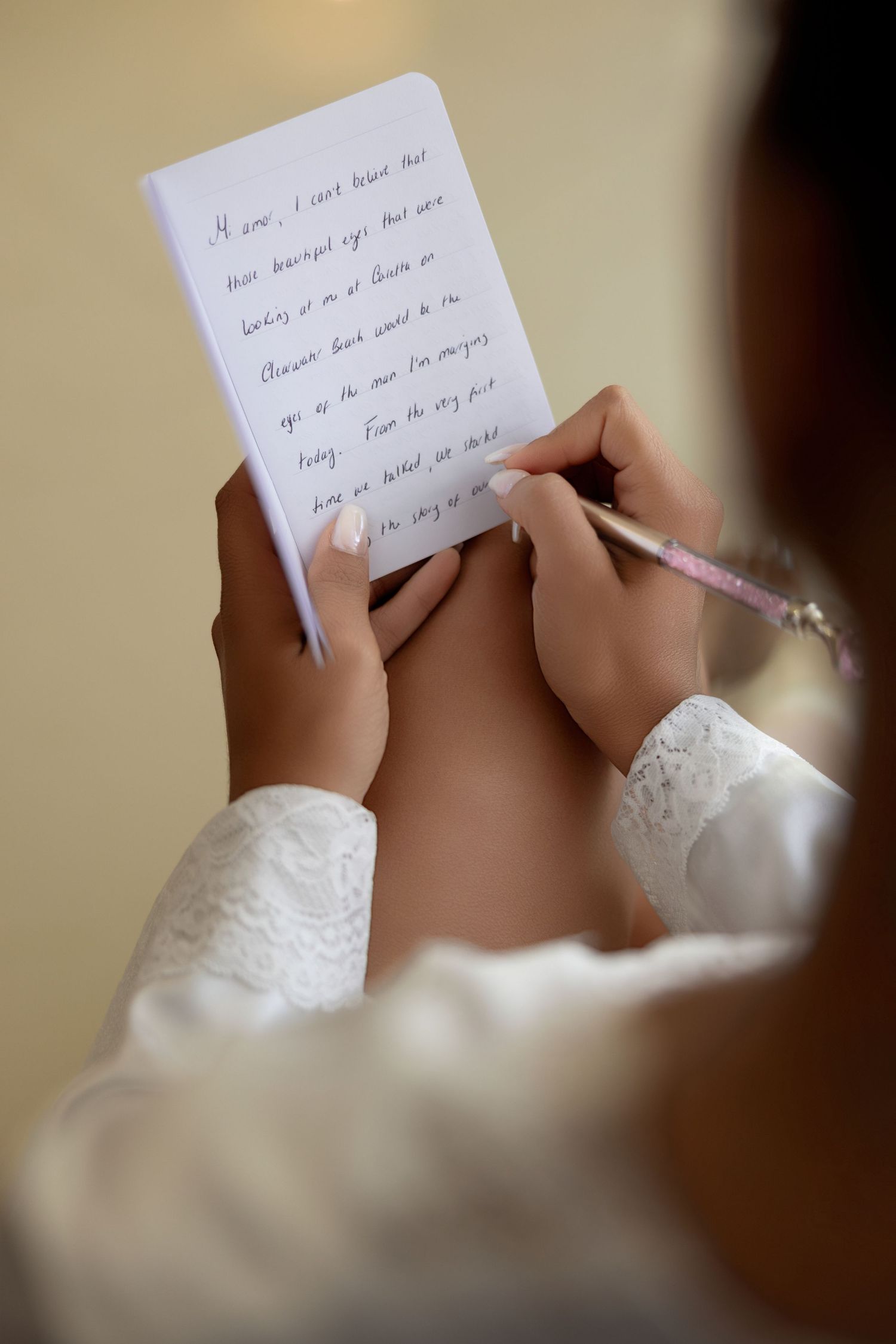 Bride writing her wedding vows on paper during a romantic wedding preparation moment