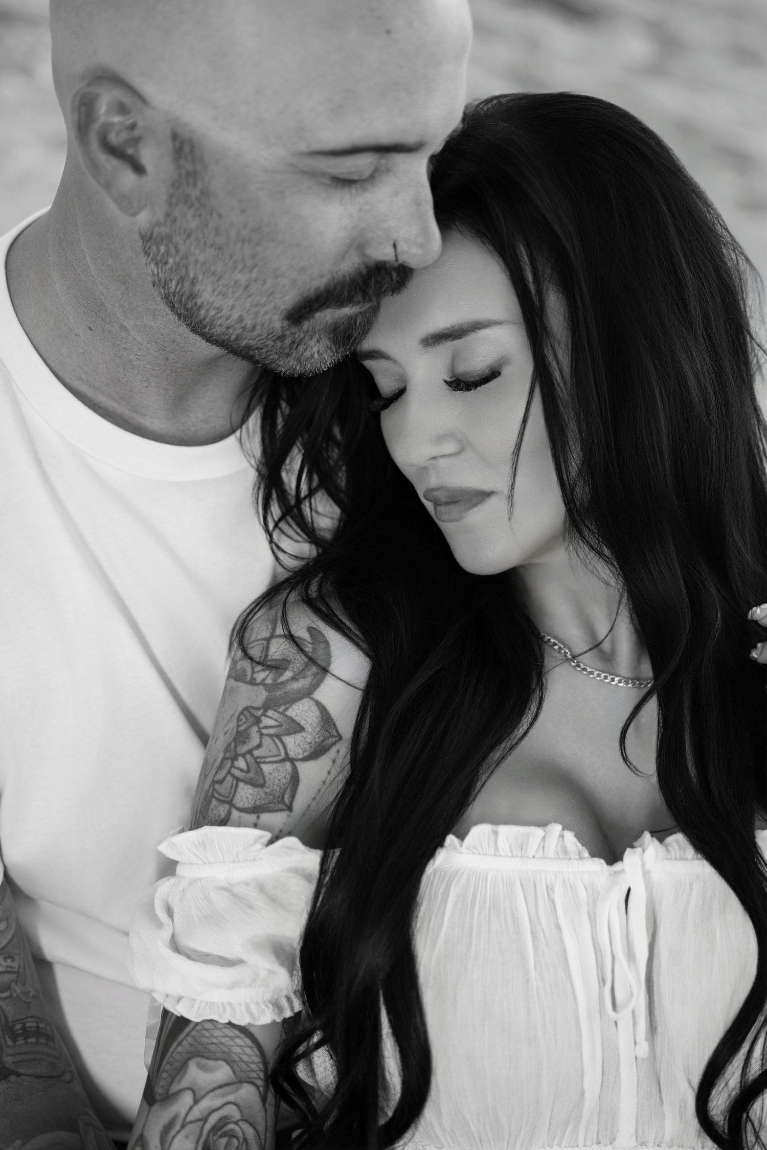 Black and white close-up portrait of an affectionate couple cuddling with eyes closed