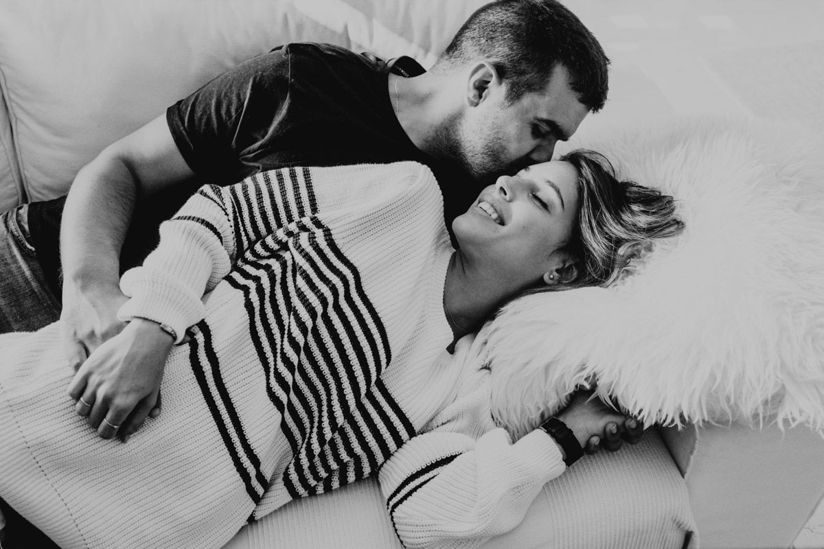 A black and white intimate portrait of a couple sharing a tender moment.