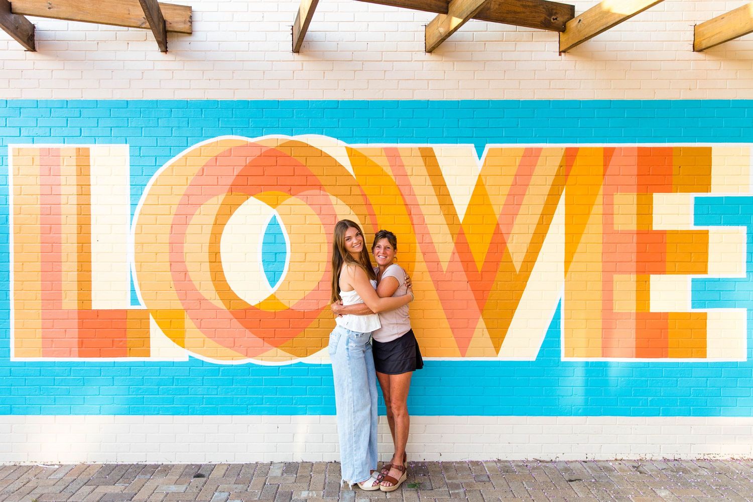 RVA Richmond Virginia senior photographer.  Daughter and mom standing in front of a LOVE mural in Ashland, Va.