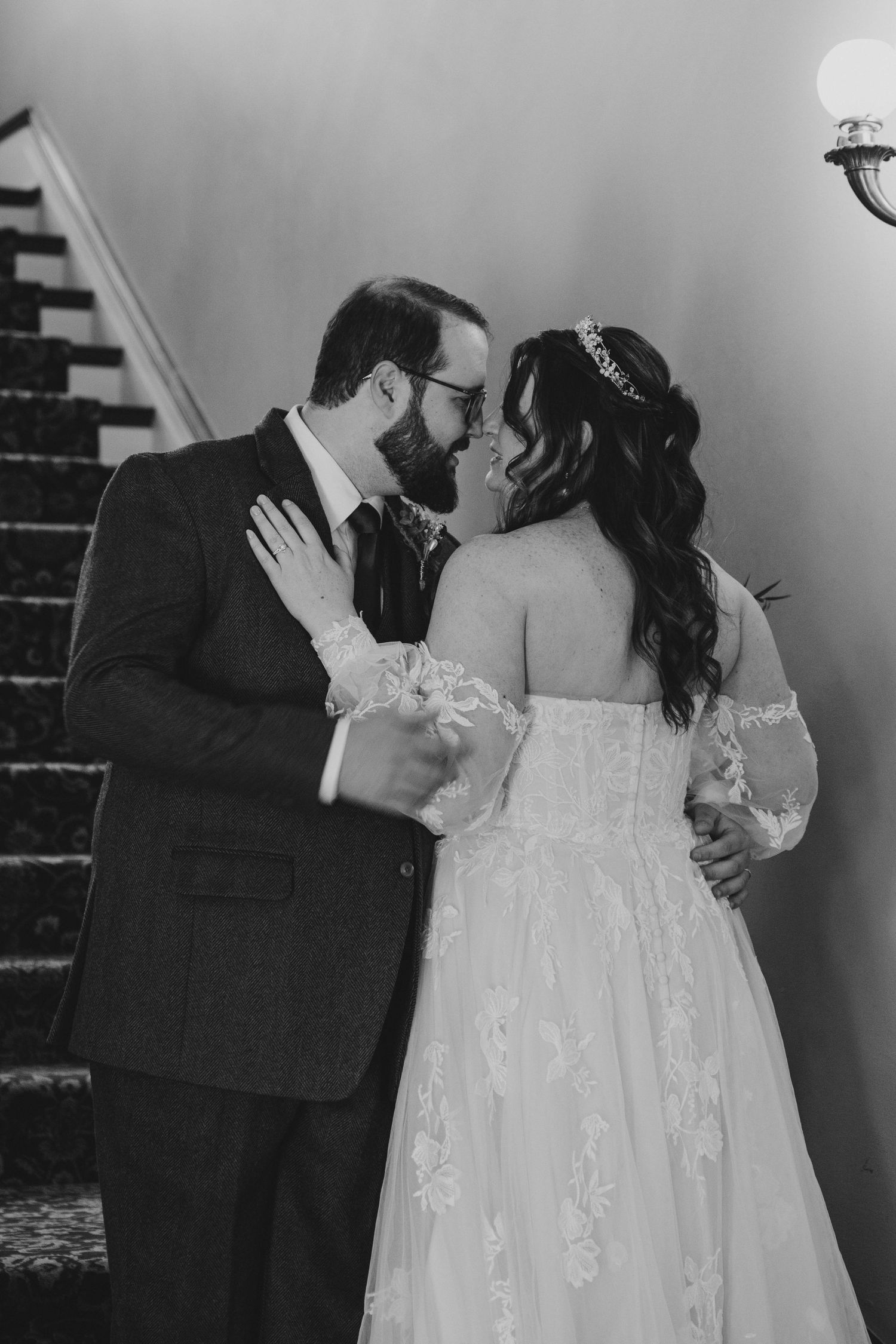 Romantic black and white portrait of couple embracing during wedding ceremony.