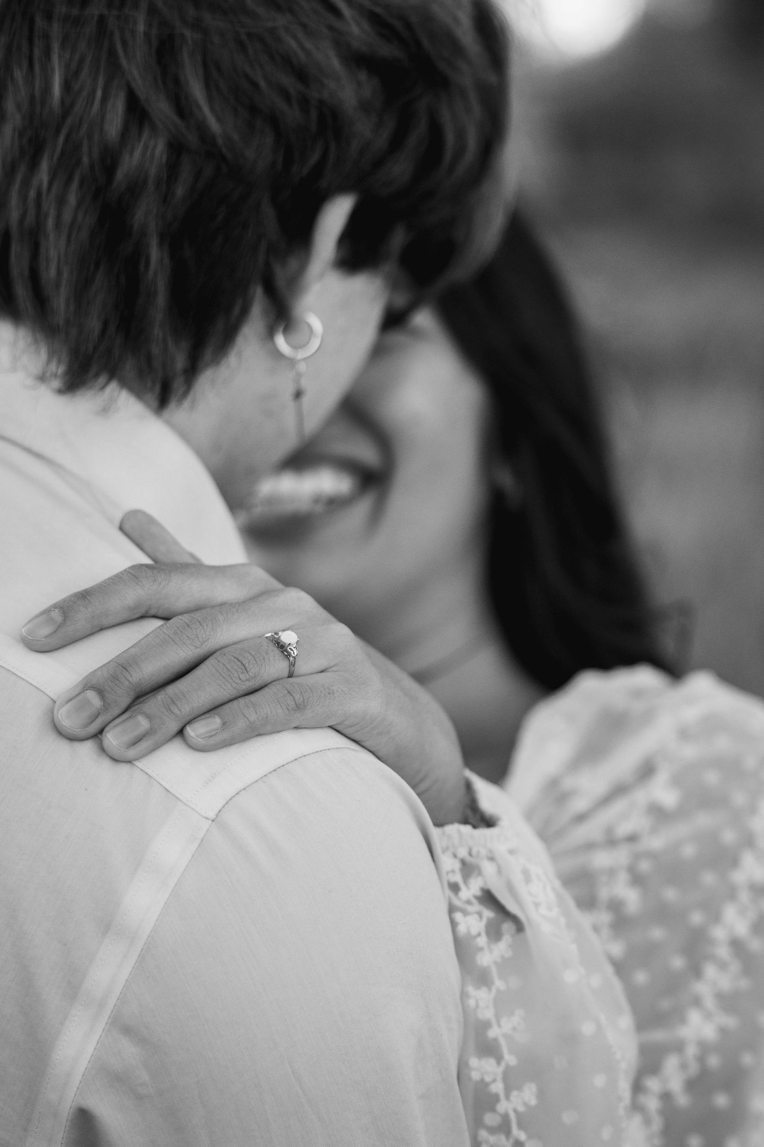 Intimate black and white portrait capturing tender embrace with lace details.