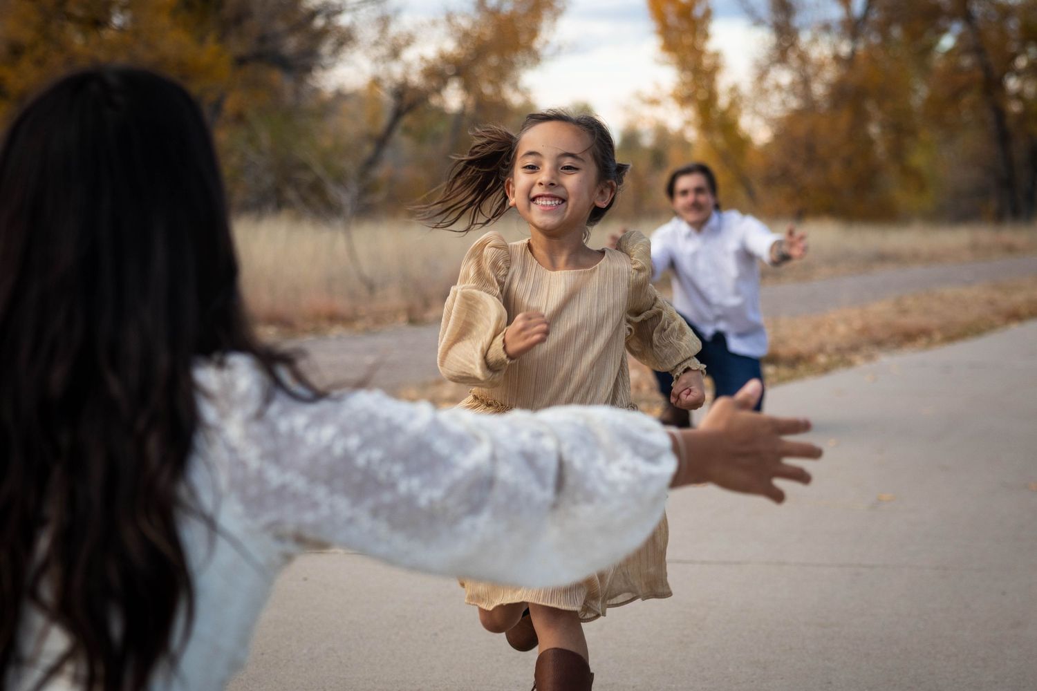 Joyful family interaction captured during outdoor photo session in autumn setting.