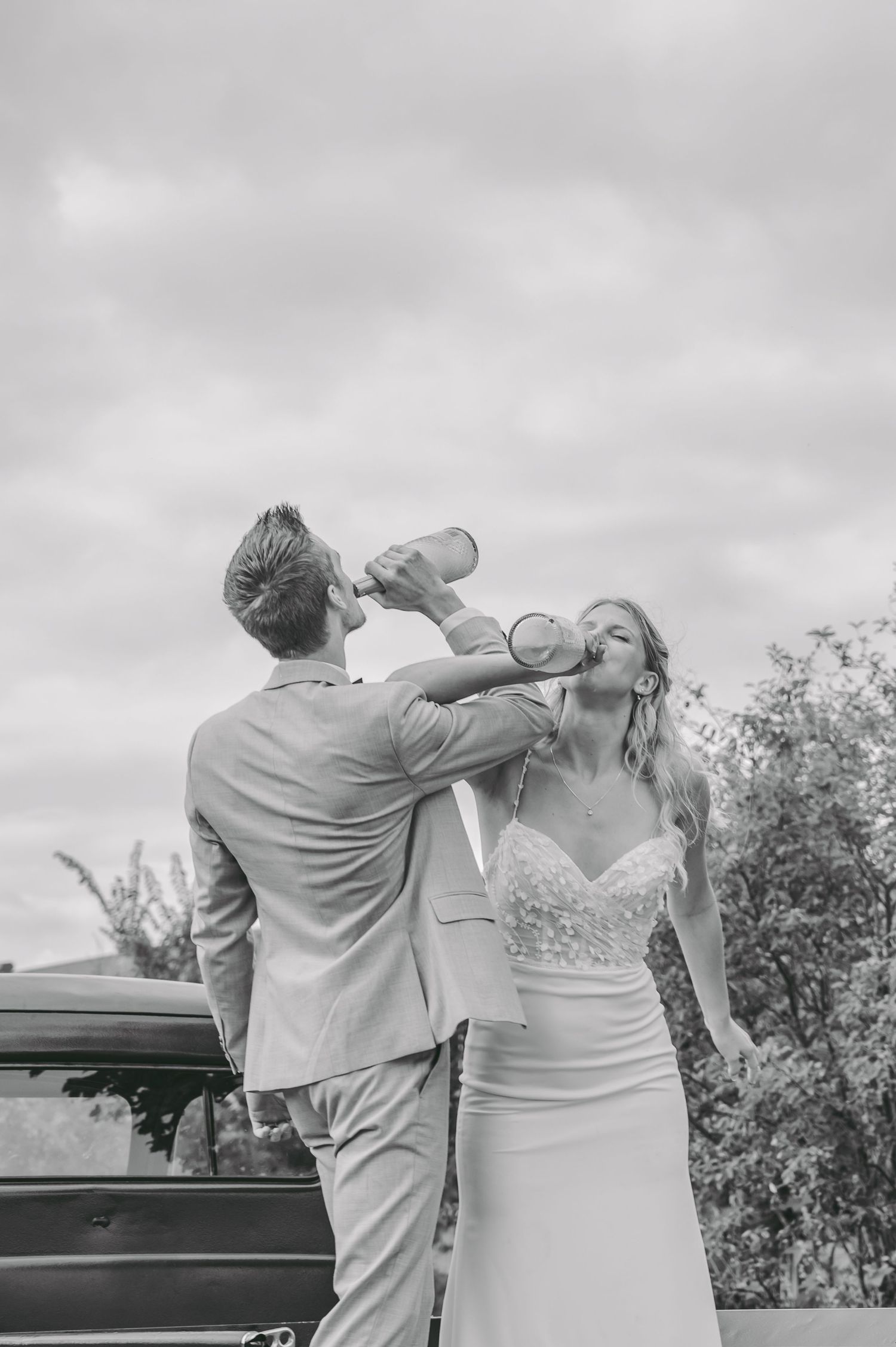 A couple in formal attire performs a synchronized drinking pose in a black and white wedding photo sequence.