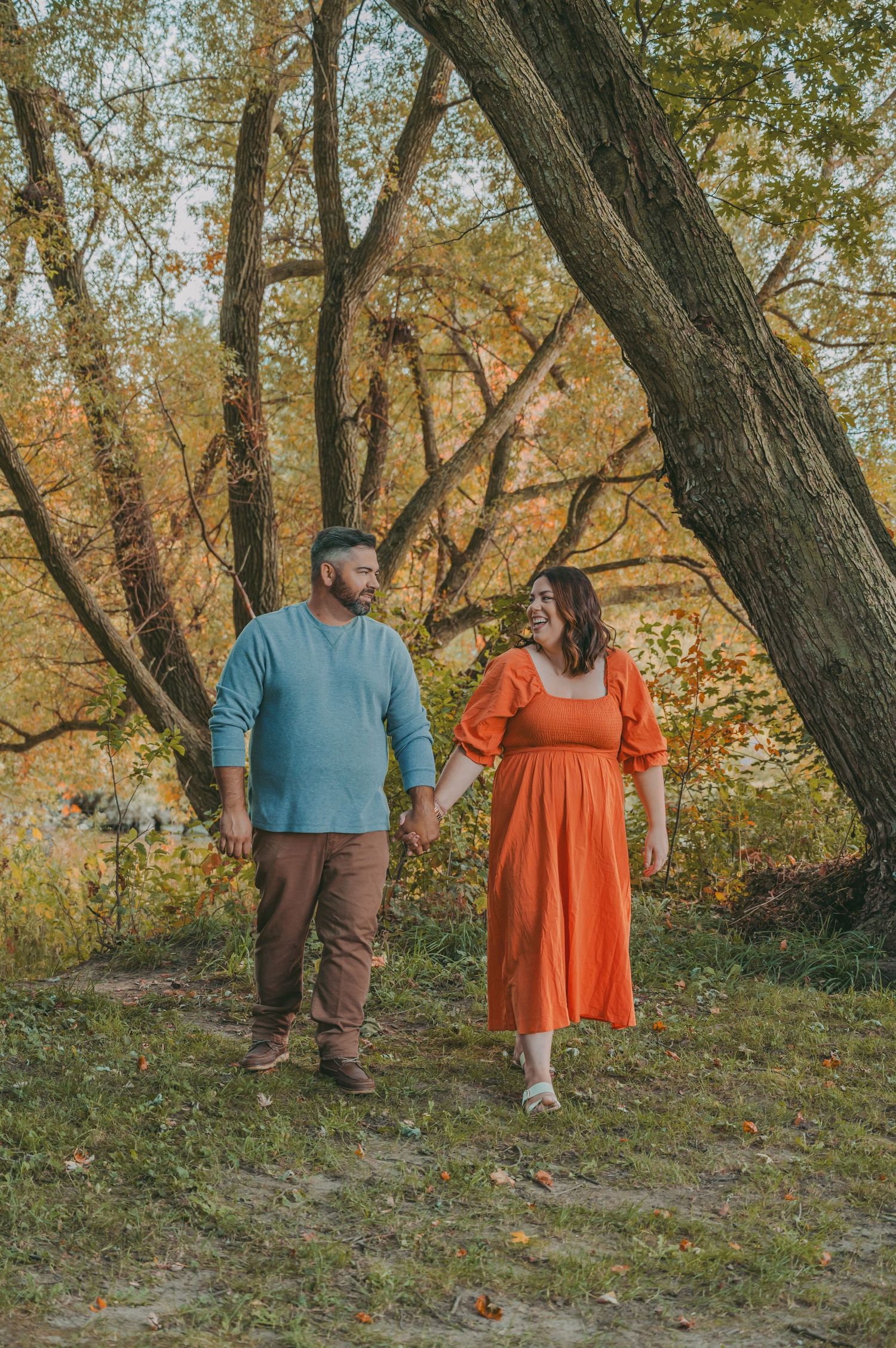 A couple takes a romantic autumn stroll in matching casual outfits.