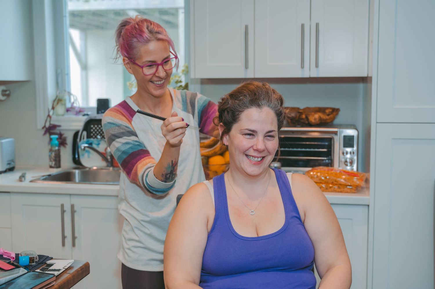 Pre-wedding preparations in a bright kitchen with colorful hair styling.