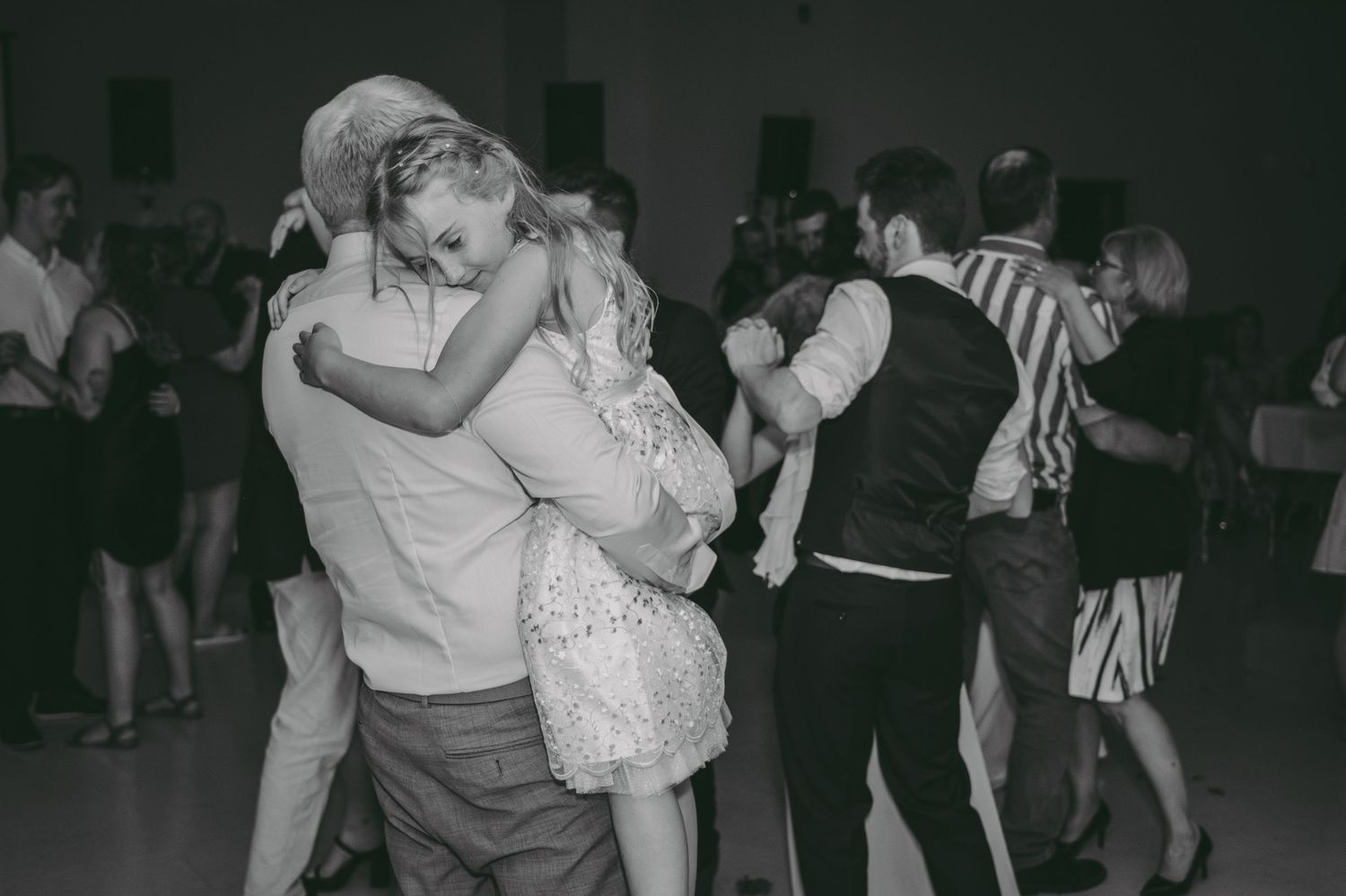 Black and white photo of couples dancing romantically as a father hold his daughter.