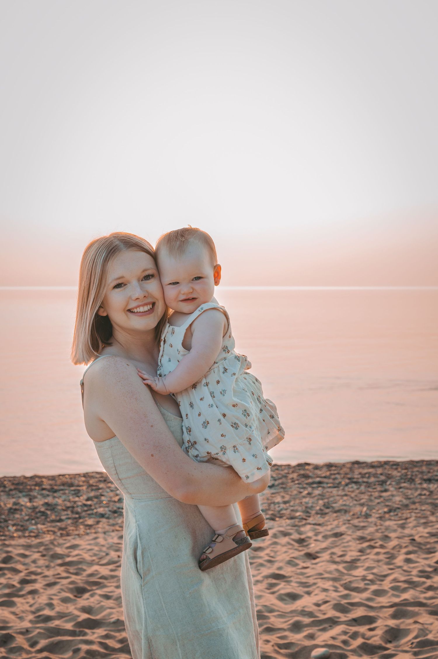 A tender sunset moment on a beach with warm peachy tones.
