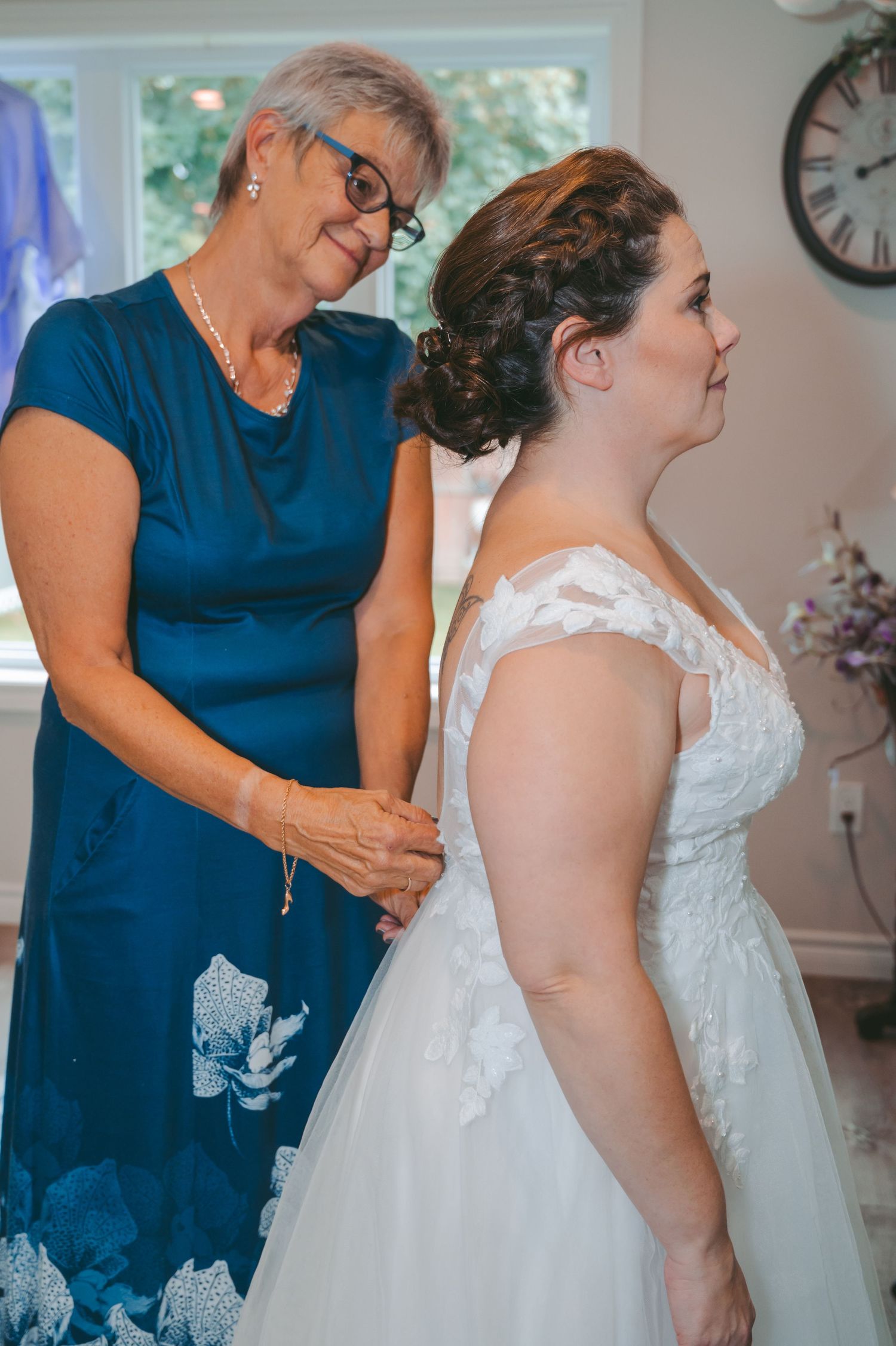 Final dress adjustments being made to a beautiful white wedding gown.
