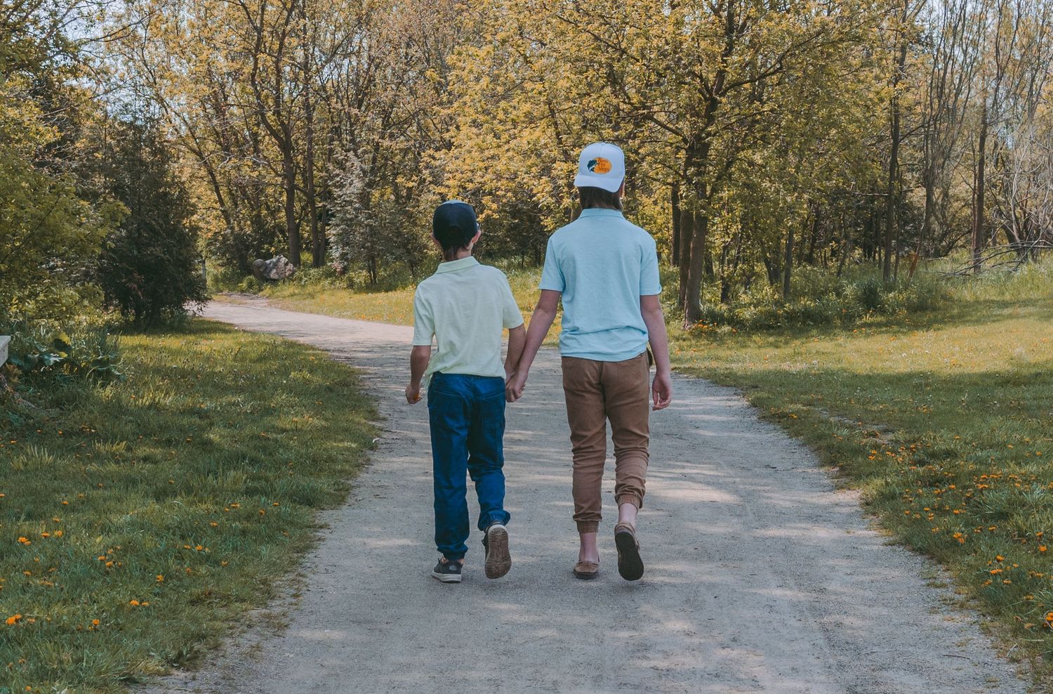Two people walking together on path through autumn woods.