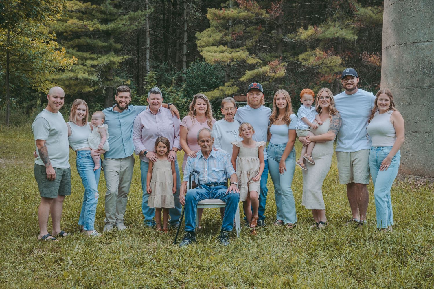 Extended family posing together outdoors in coordinated blue and white outfits.