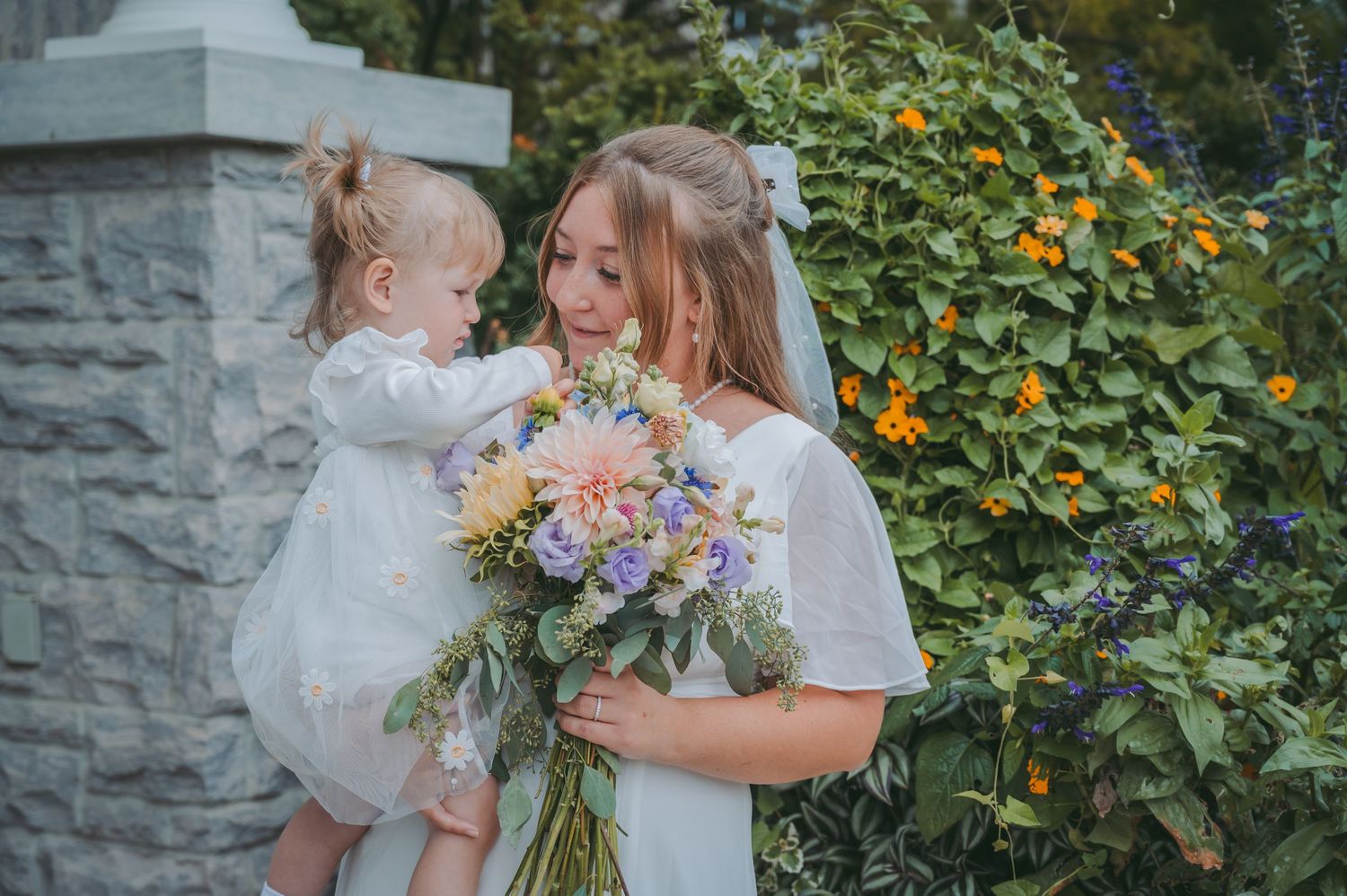 Beautiful floral arrangements frame a joyful wedding moment in a garden setting.