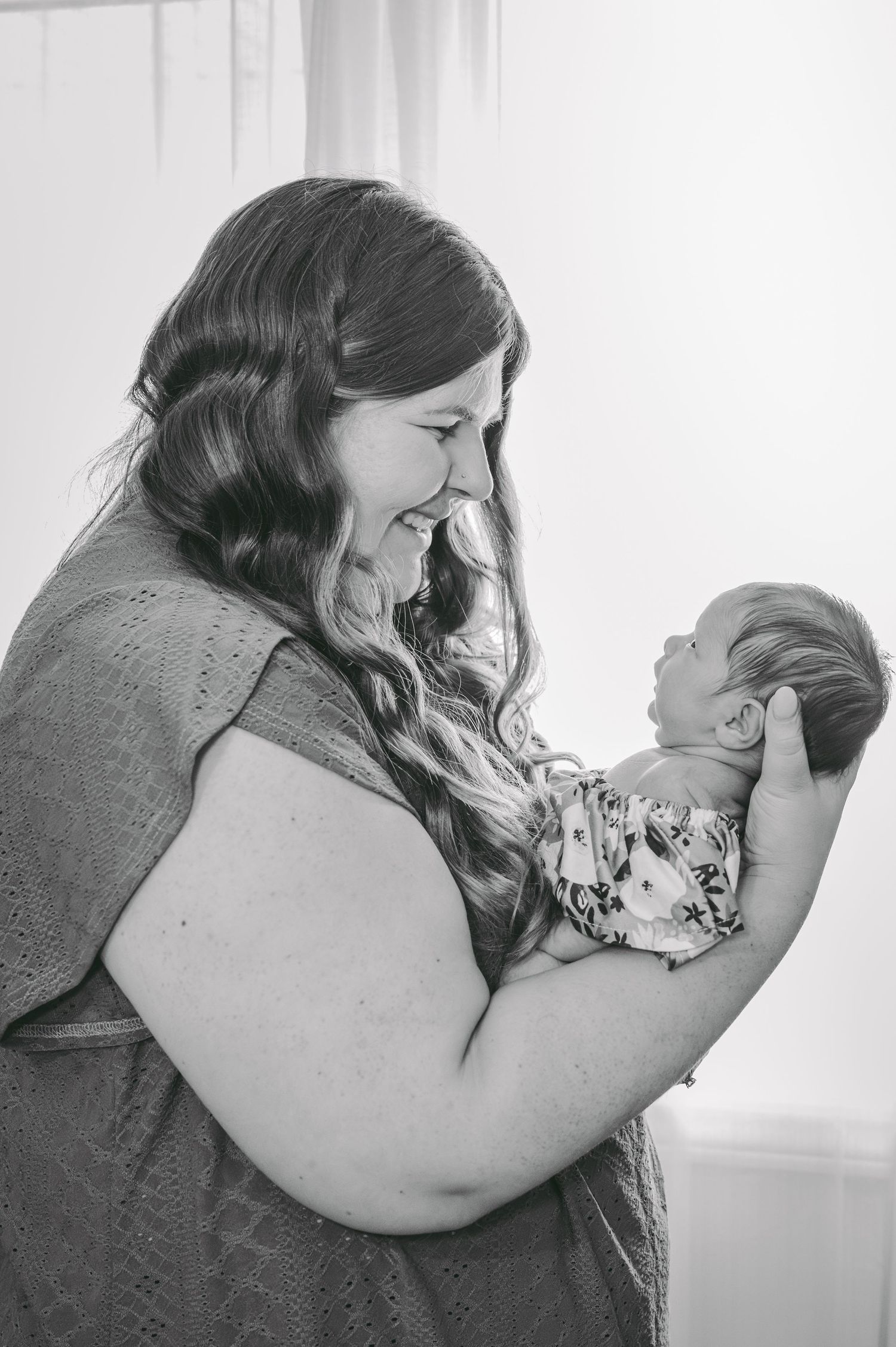 Tender black and white portrait of parent and newborn sharing intimate moment.