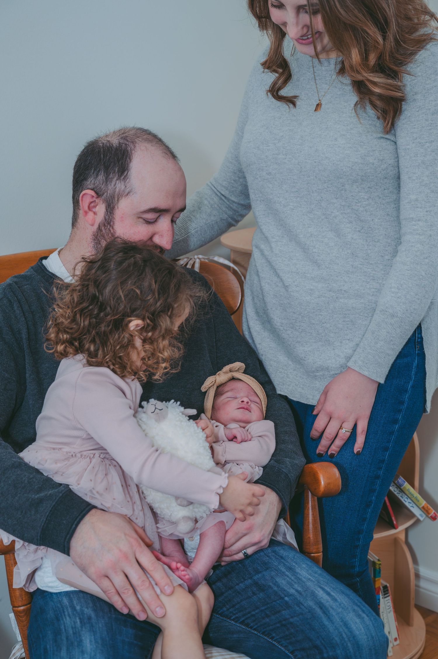 An intimate family moment captured indoors with a baby in soft natural light.