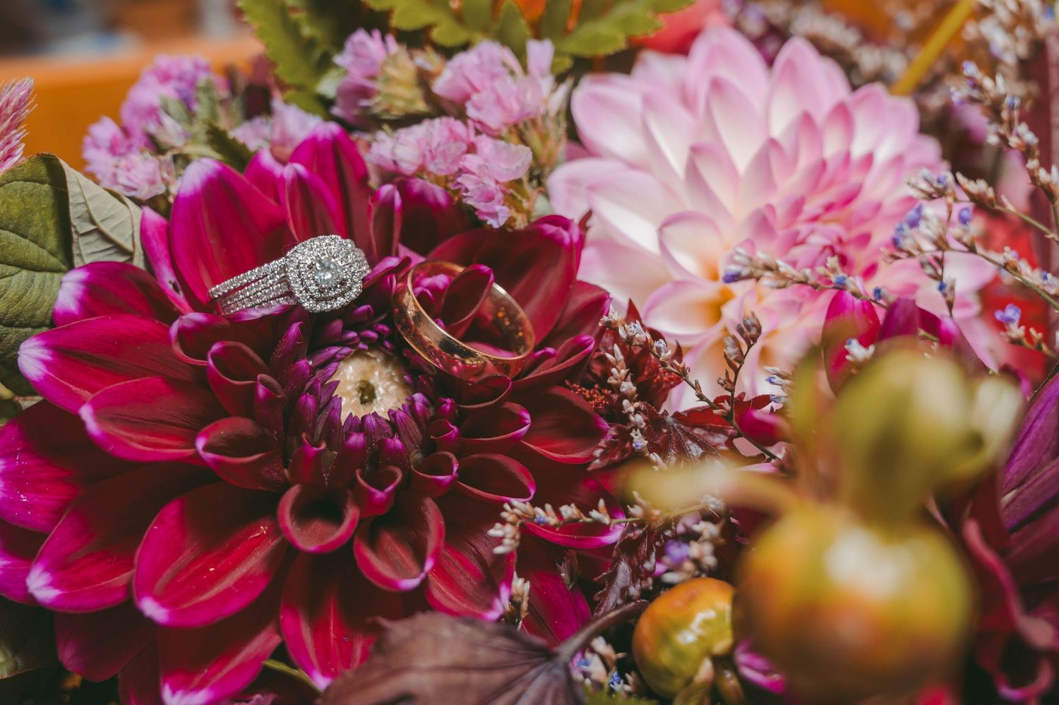 Close-up of vibrant pink and red dahlias with decorative floral arrangements.