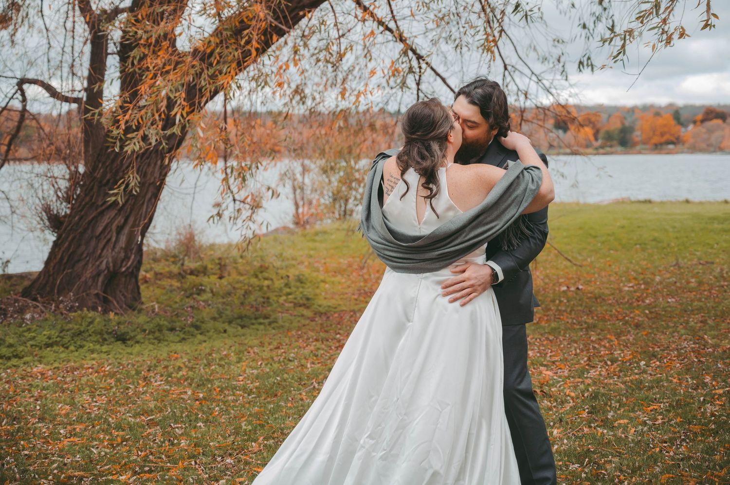 Autumn wedding couple photography session with fall foliage and trees in background.