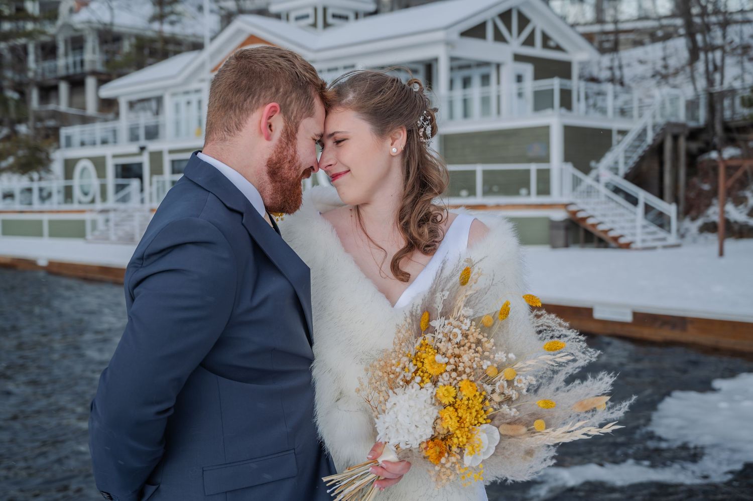 A romantic winter wedding scene with a snowy backdrop and yellow floral bouquet at the Touch Stone Resort.