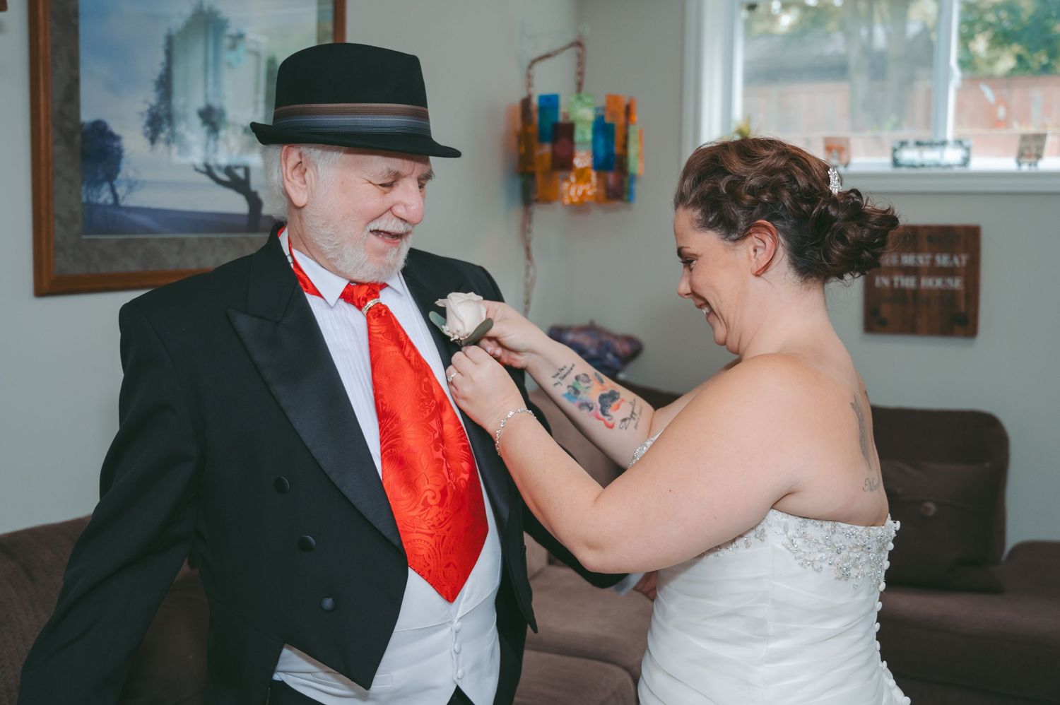 An emotional moment as someone adjusts a formal black suit and red tie.
