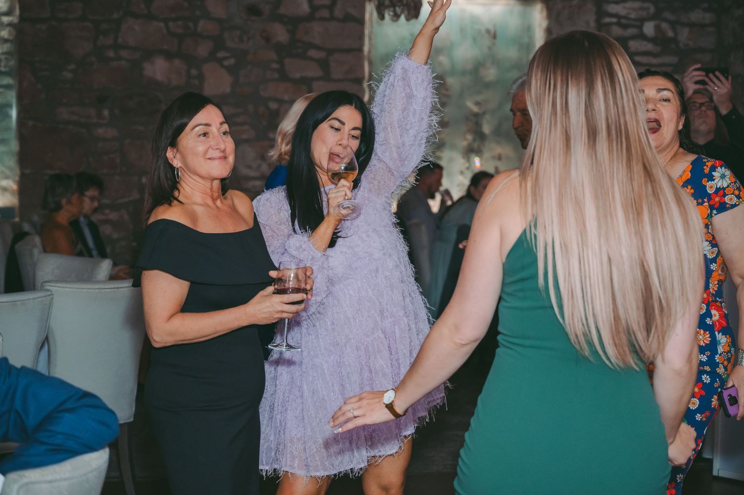 Wedding guests dancing and celebrating at a lively reception party.