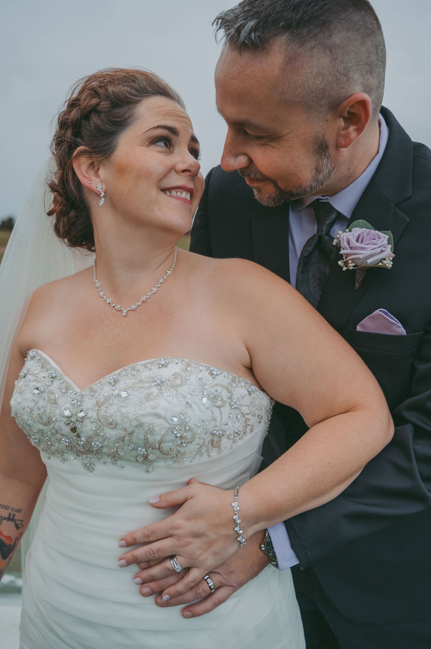 Close-up wedding portrait showing beautiful bridal jewelry and details of the dress.