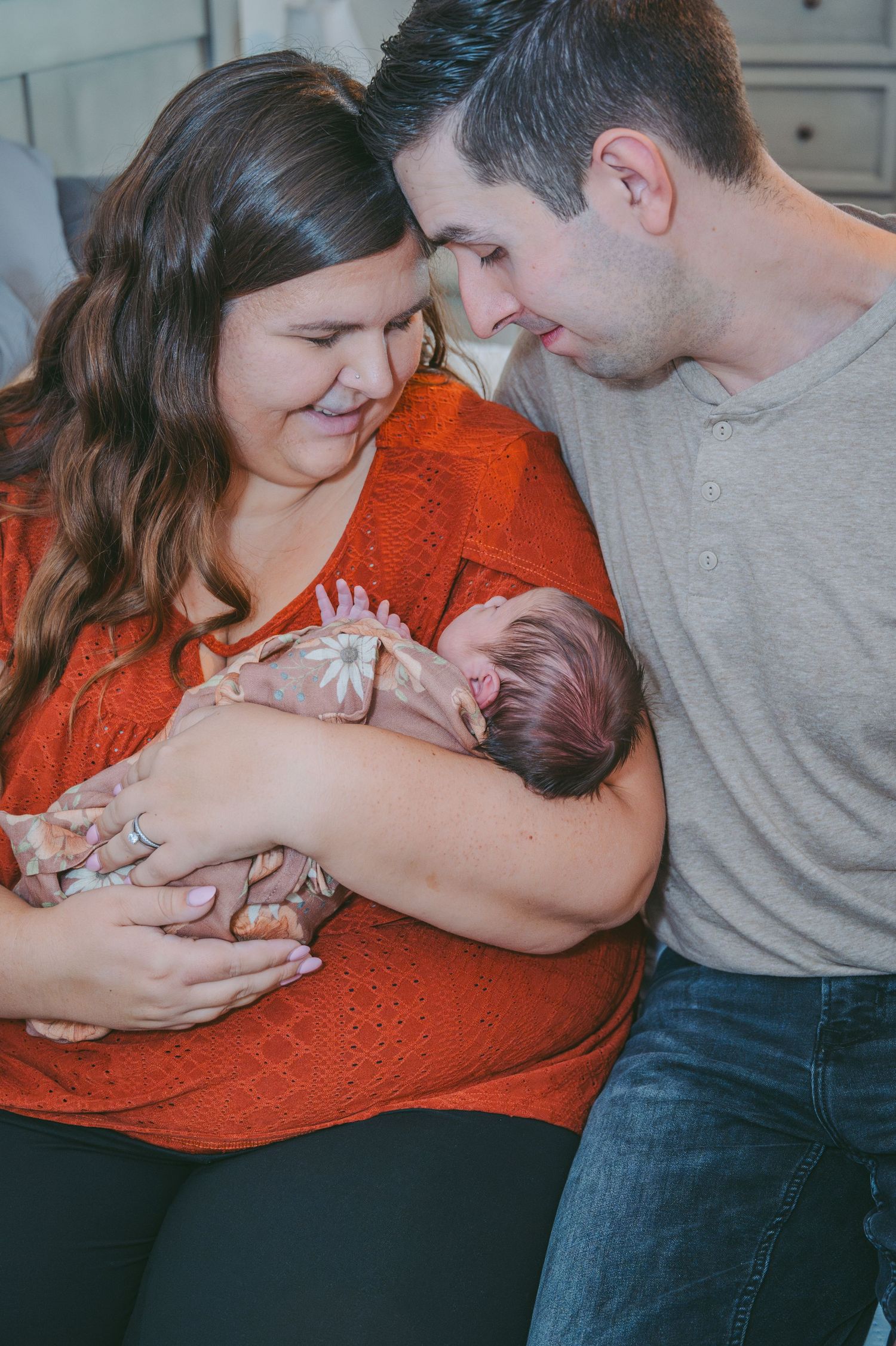 Candid portrait of parents lovingly gazing at their newborn.