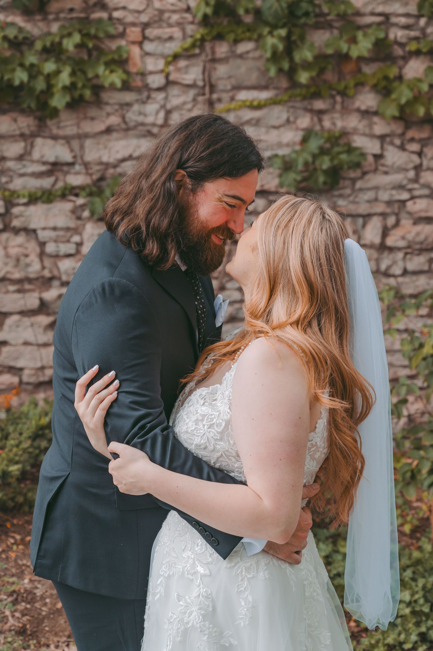 A romantic wedding couple embraces against a rustic stone wall with ivy, captured in a series of intimate moments.
