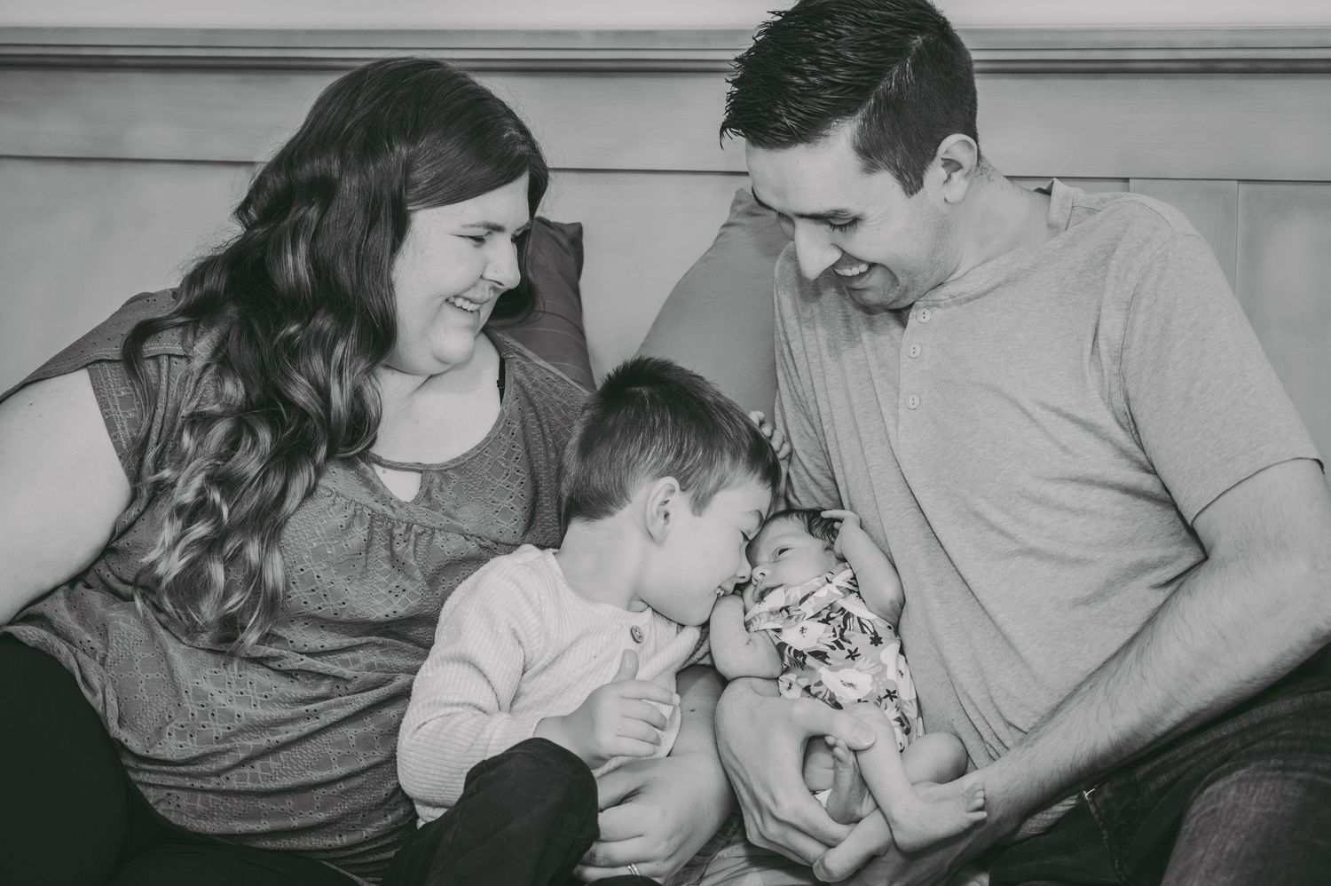 An intimate family portrait showing tender interaction with a newborn.