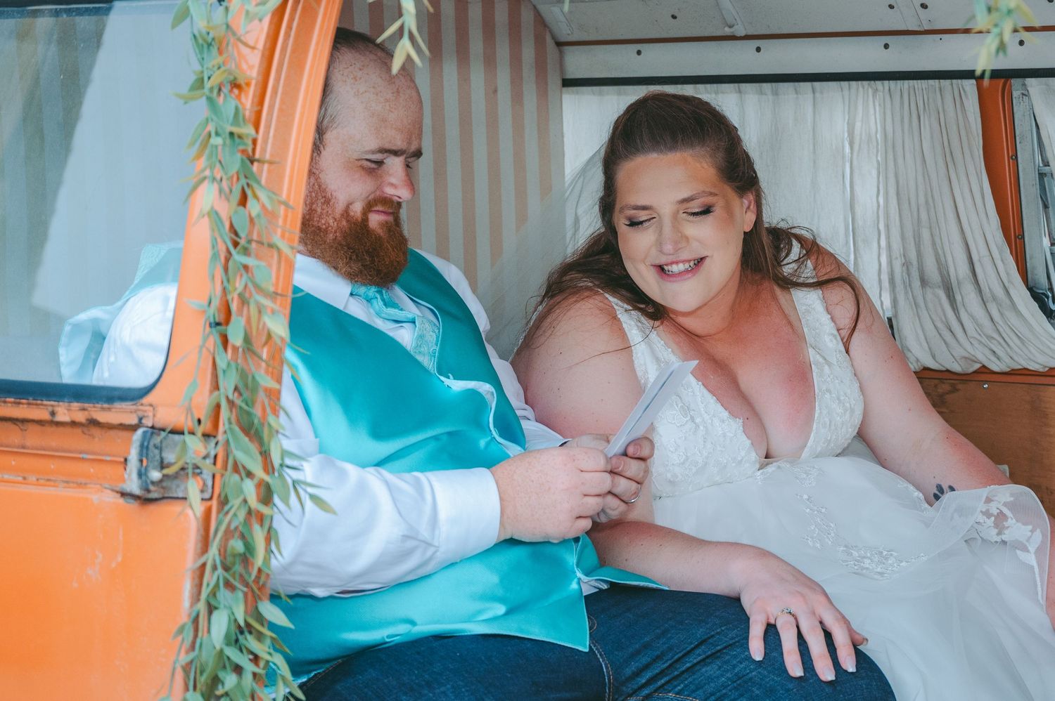 A couple shares an intimate moment in a vintage-style setting with teal and orange decor.