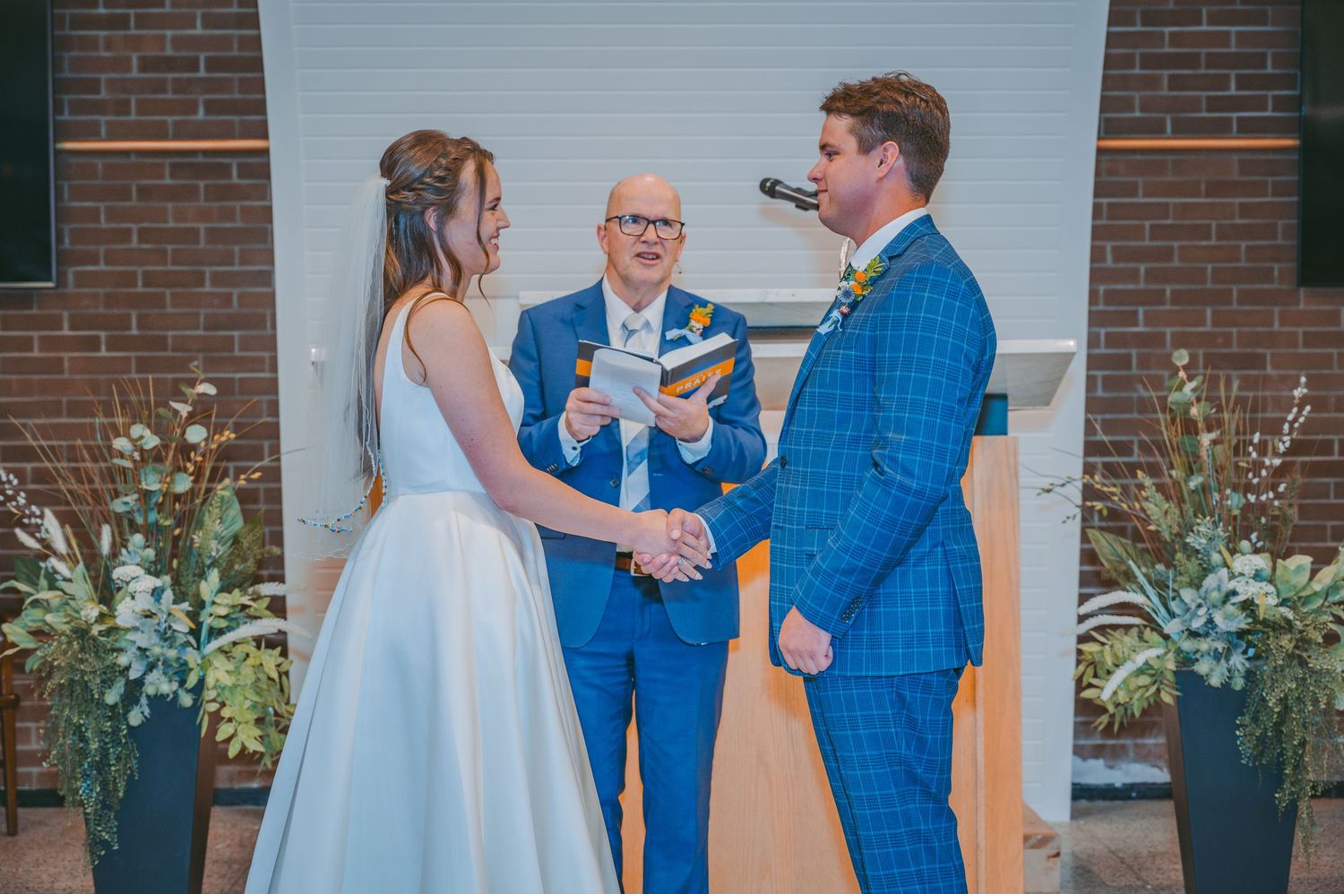 Wedding ceremony at the altar with a couple exchanging vows in front of an officiant.