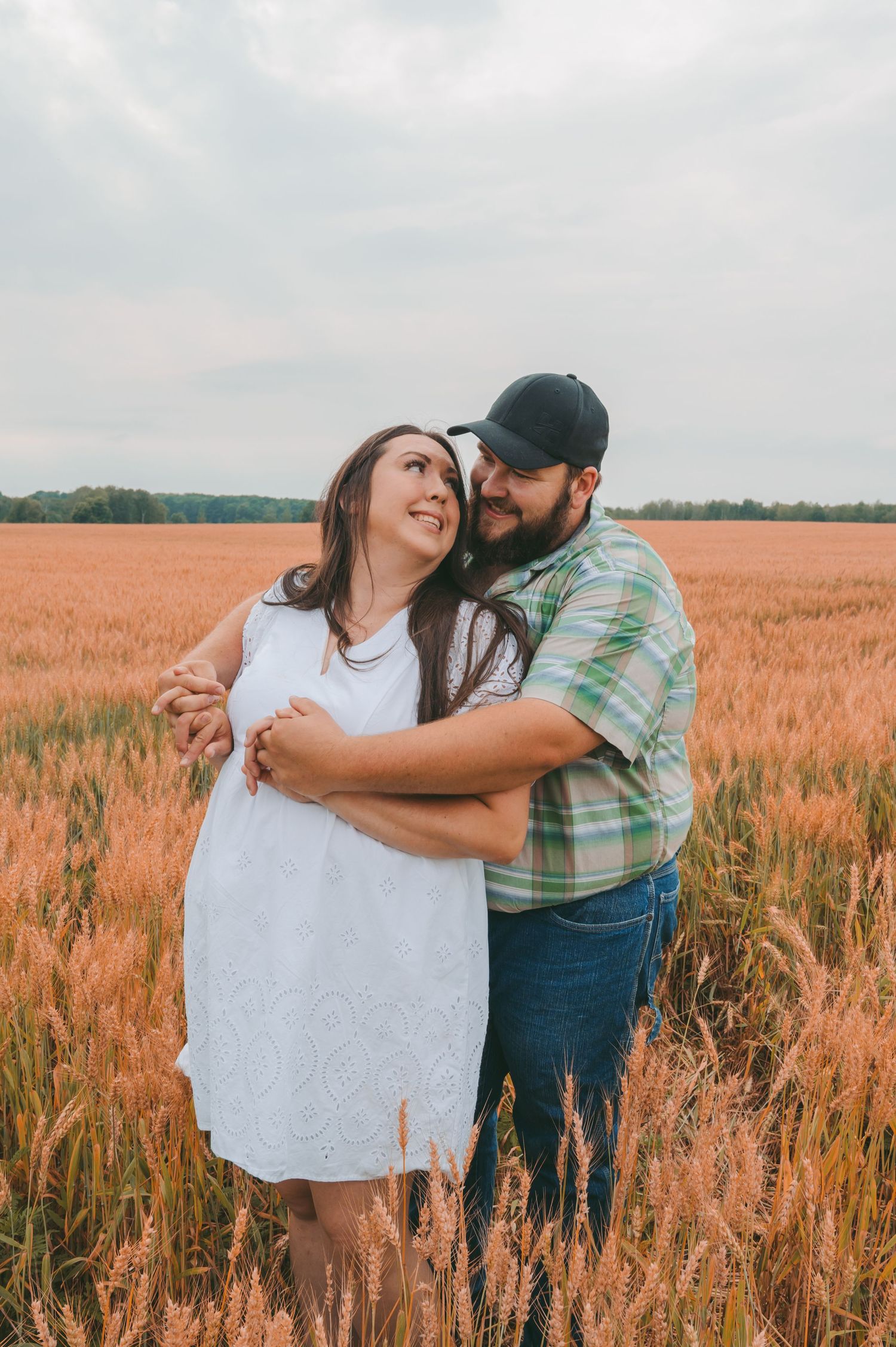 A joyful embrace between partners in a golden wheat field.