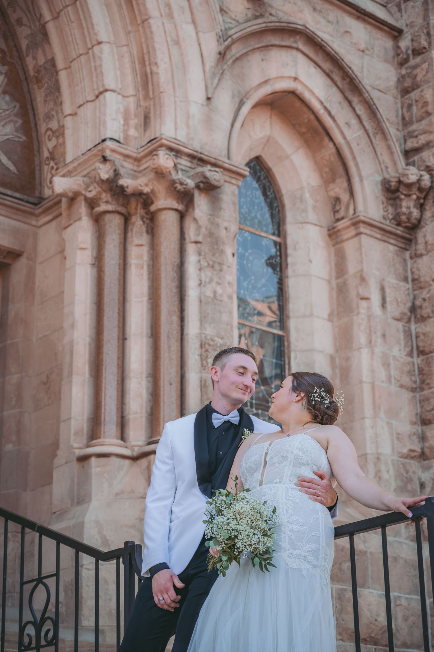 Romantic wedding couple shares intimate moments in front of Basilica of Our Lady Immaculate.