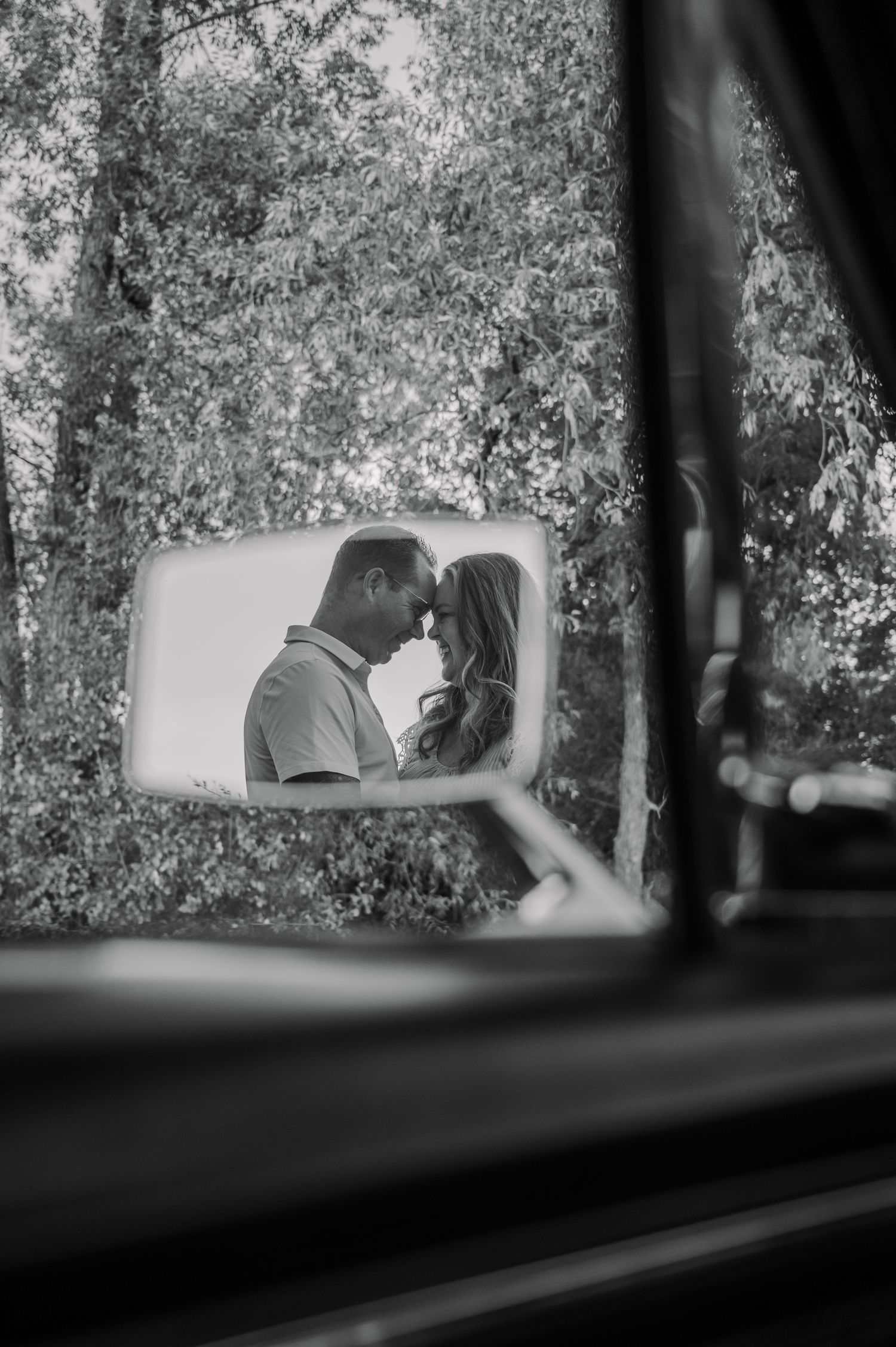 Black and white sequence of rearview mirror reflections showing a car interior and trees in the background.