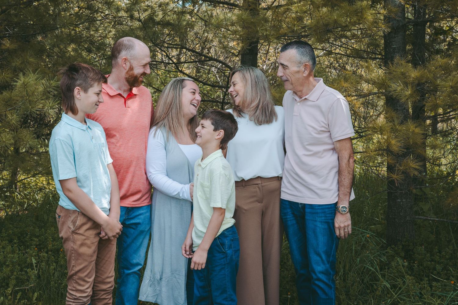 Extended family sharing candid moment together outdoors in natural setting.