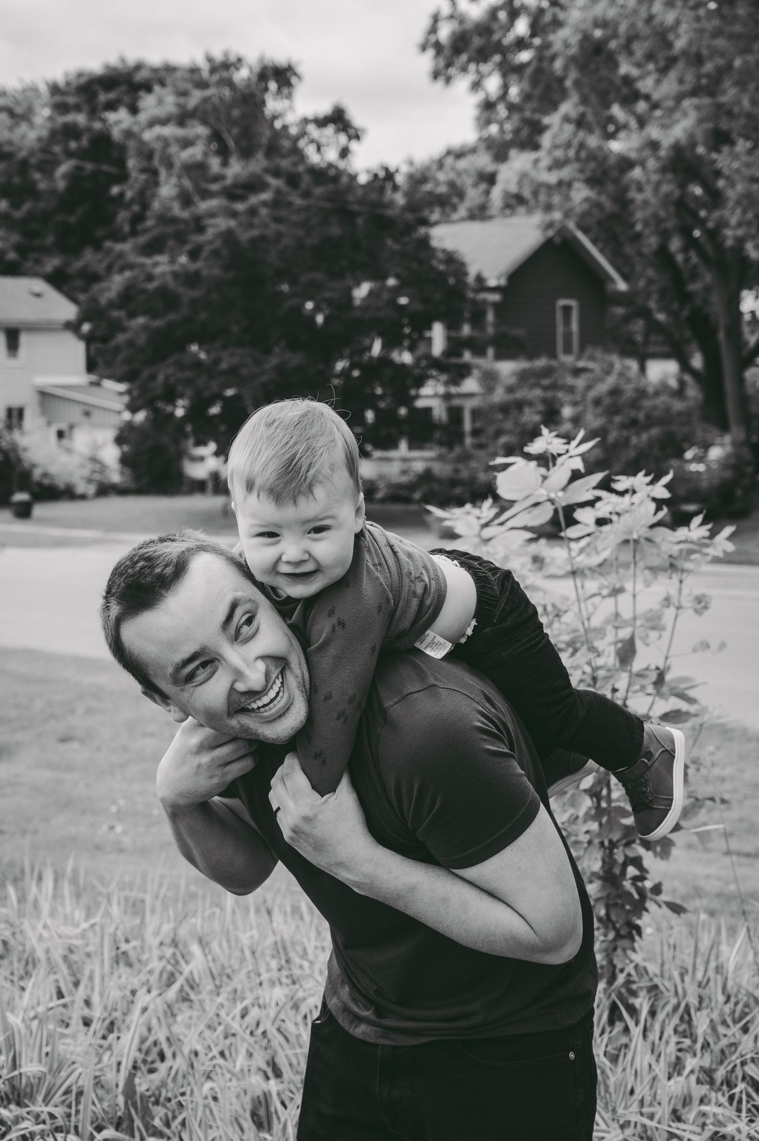 A joyful moment shared between parent and child in a black and white outdoor setting.